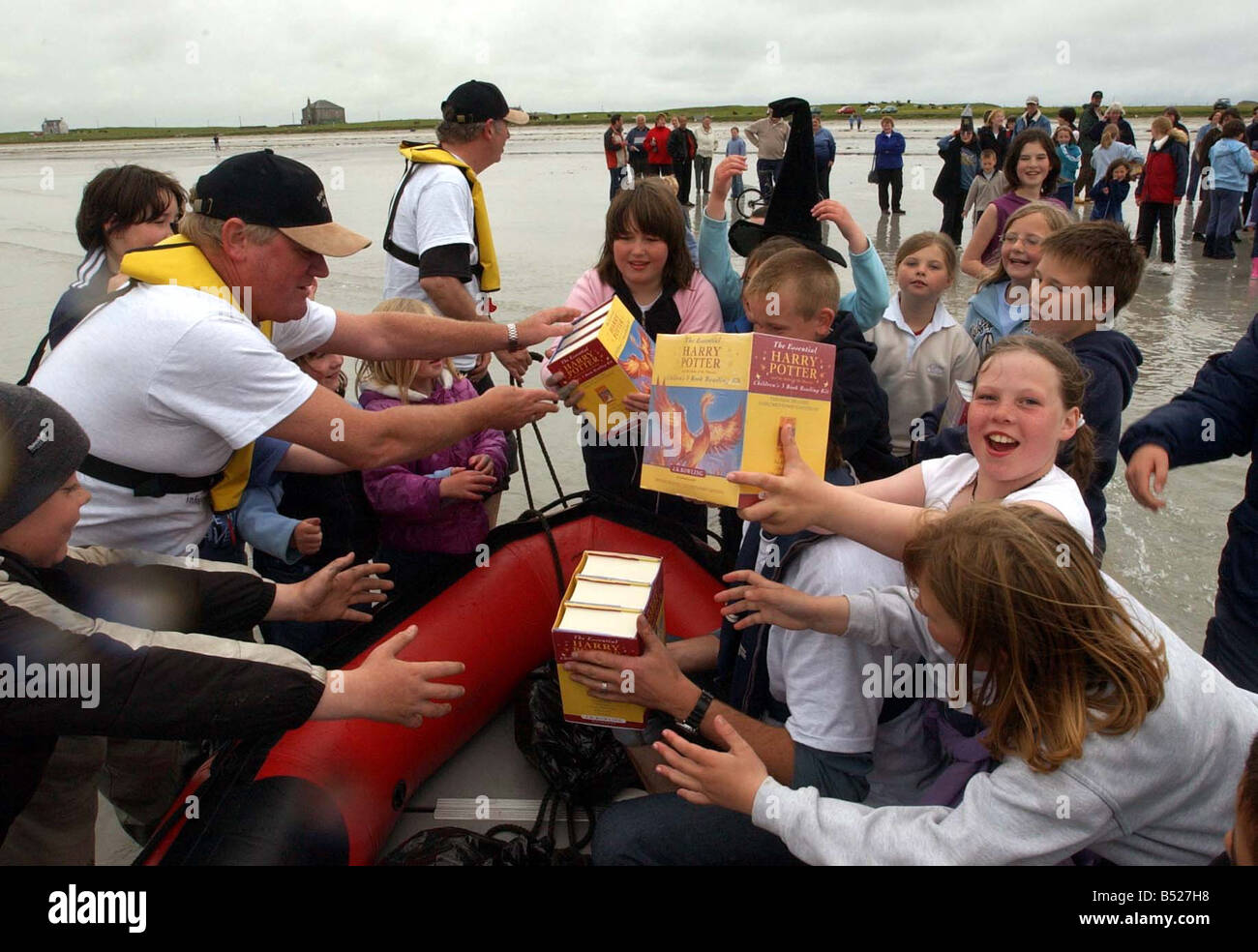 Lecture des enfants des copies de livre de Harry Potter, l'Ordre du Phoenix, livrés à eux sur l'île de Tiree, Frontières de livres à Glasgow. Banque D'Images