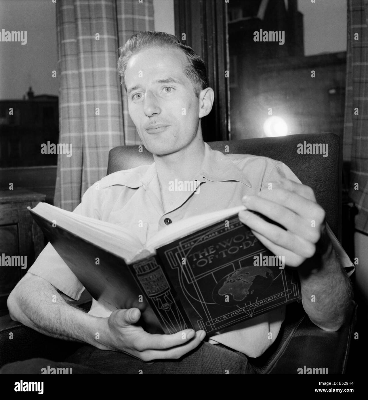Les familles. Man reading book. Juillet 1953 D3424-001 Banque D'Images