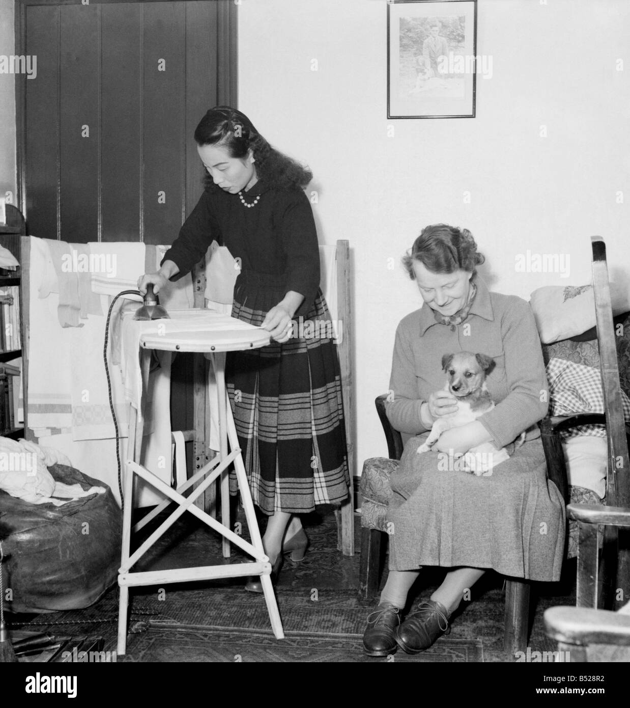 Scènes domestiques Une femme planche dans le salon de sa maison &# 13 ;&# 10;Février 1953 &# 13 ;&# 10;D613 Banque D'Images