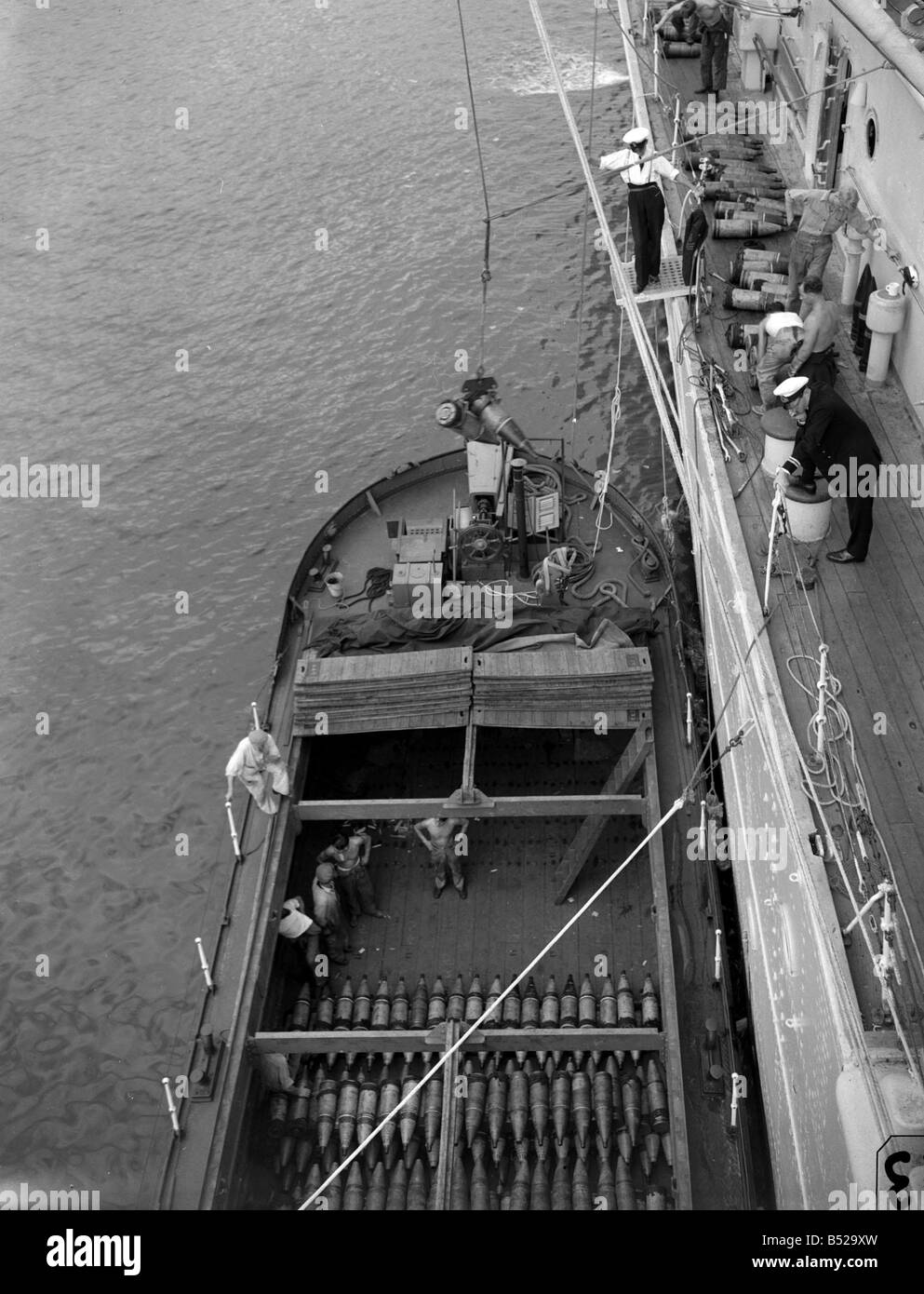 L'équipage de la classe de croiseur HMS London en tenant compte des fournitures et des munitions d'une barge après qu'elle ait été endommagée Banque D'Images