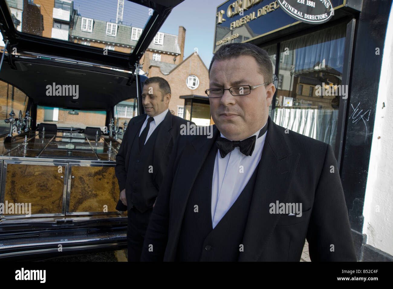 Deux pompes funèbres en attente d'un cercueil, en regard de leur corbillard Hackney, Dalston, East London Banque D'Images