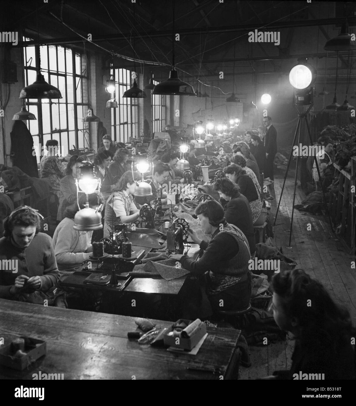 Vêtements filles à l'usine travaille dans l'Est de Londres recherche bougie utiliser pour l'éclairage des feux. &# 13 ;&# 10;Avril 1947 O6777 Banque D'Images
