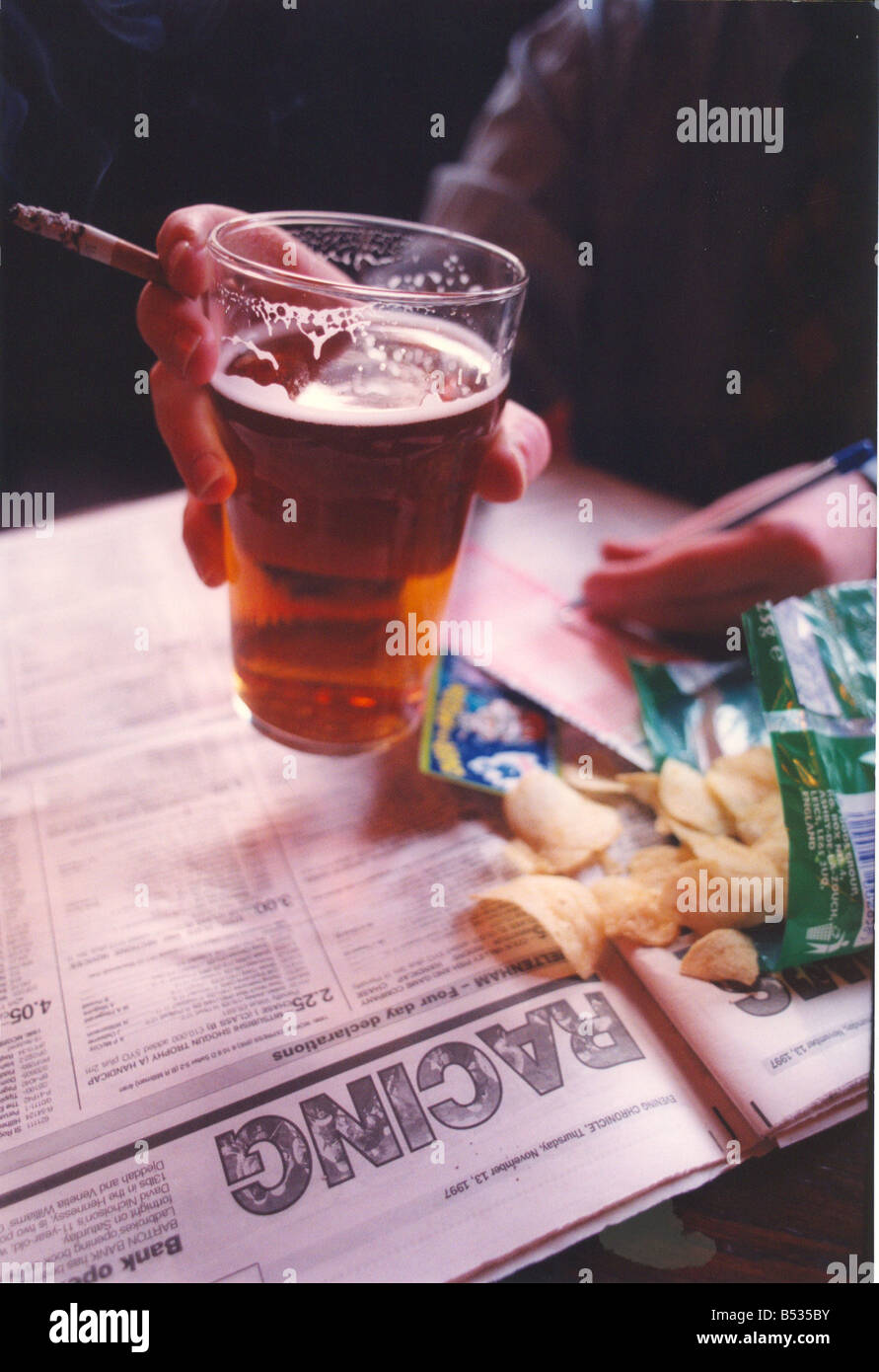 Péchés capitaux quatre pintes de bière boire fumer et jouer avec un peu de la malbouffe chips jeté dans Banque D'Images
