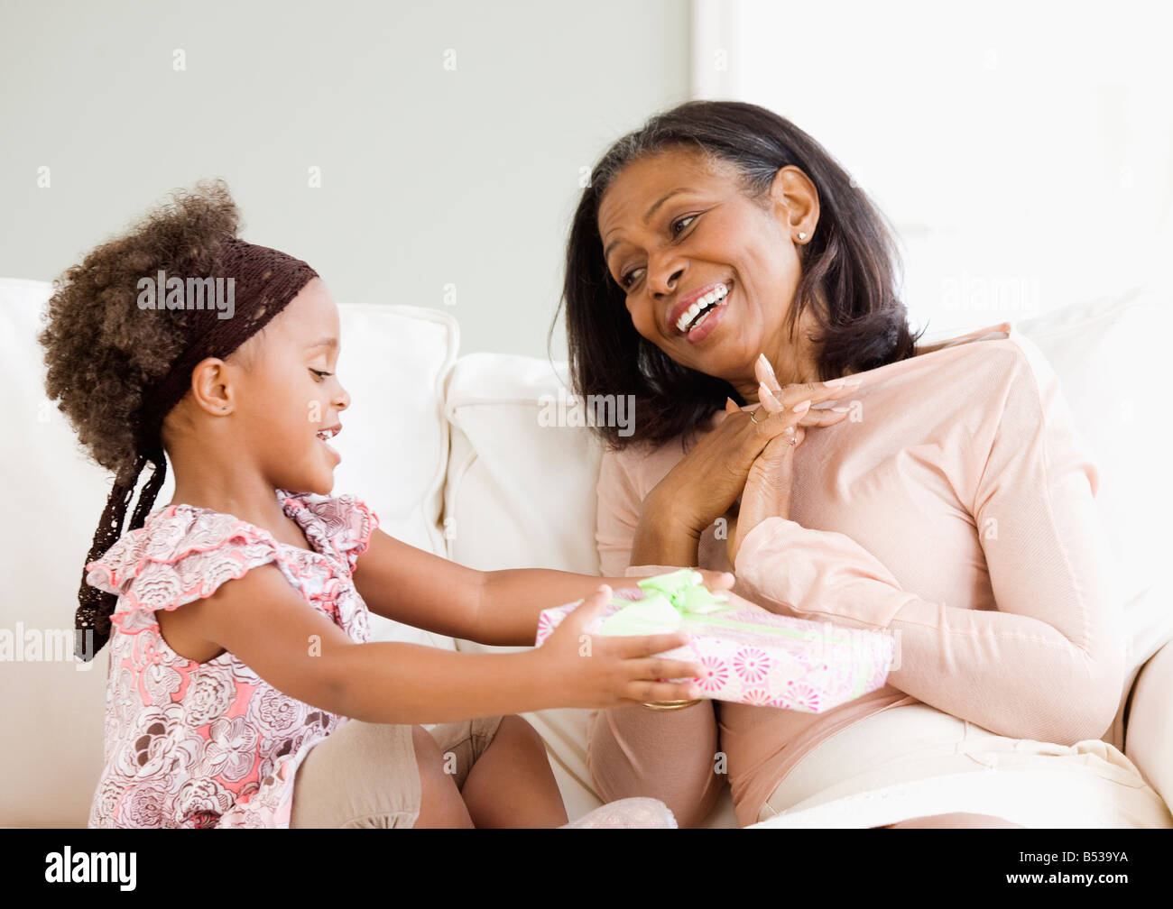 Petite-fille de l'Afrique de donner de cadeau grand-mère Banque D'Images