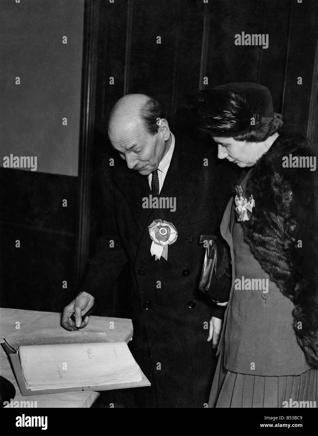 Élection générale de 1950. M. et Mme Clement Attlee regardant à travers la liste des électeurs comme la fermeture des bureaux à Walthamstow ce soir. Banque D'Images