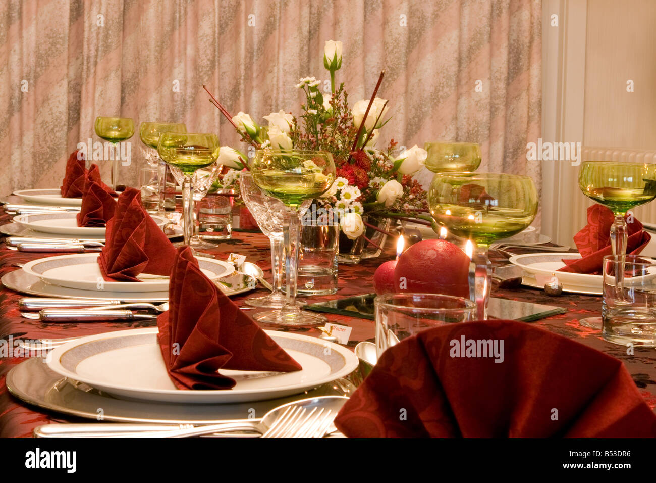 Table de dîner de Noël avec des fleurs bougies et serviettes de table rouge Banque D'Images