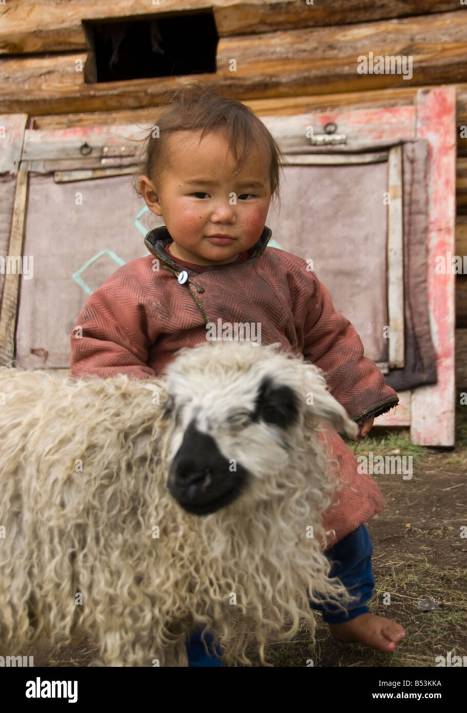 Payer l'enfant avec un agneau Mongolie Banque D'Images