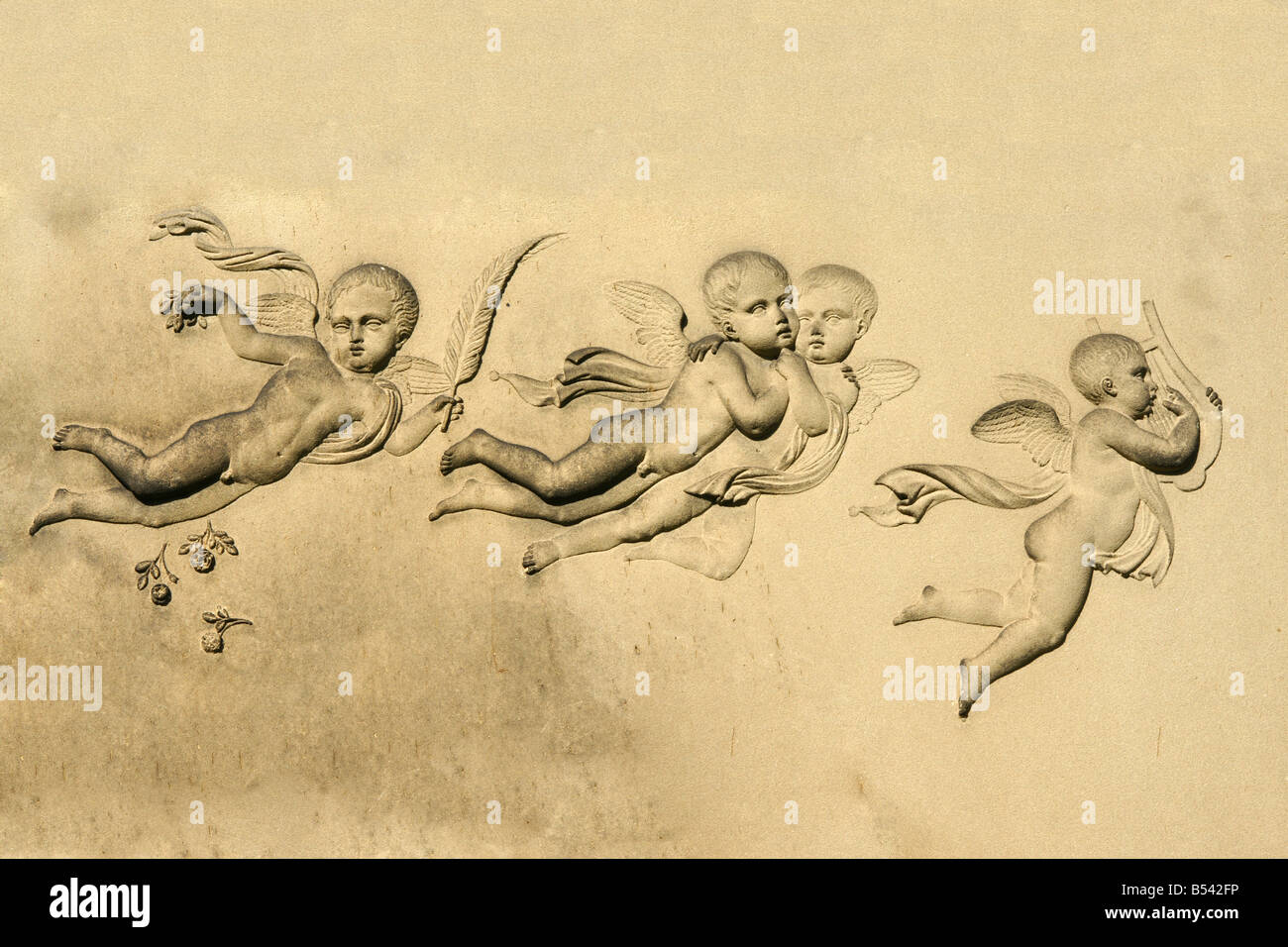 Quatre petits anges sur une pierre tombale Banque D'Images