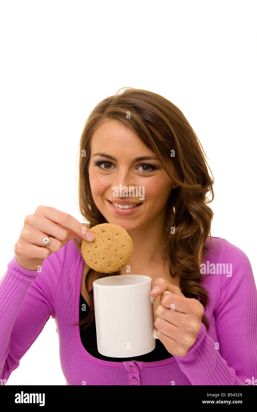 Tremper un biscuit dans femme une tasse de thé Banque D'Images