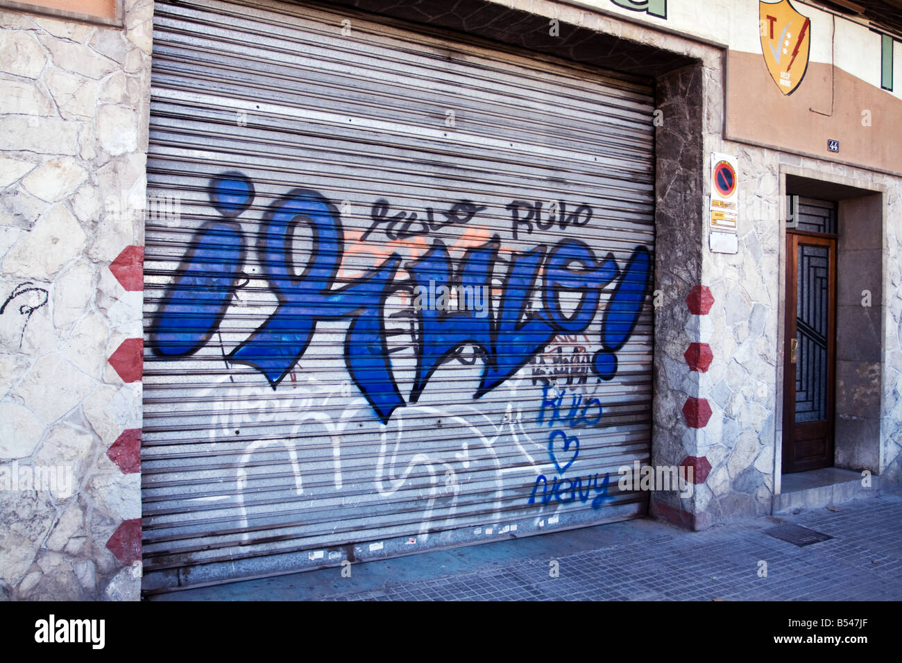 Un graffiti sur la porte de métal ondulé à Palma de Majorque. Banque D'Images