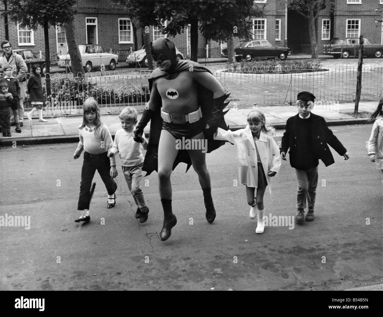 Acteur Adam West qui joue Batman, l'homme chauve-souris de Gotham City, pour aider les enfants à traverser la route en faisant une minute de film de la sécurité routière pour l'Office central de l'information. ;Mai 1967 ;P017127 Banque D'Images