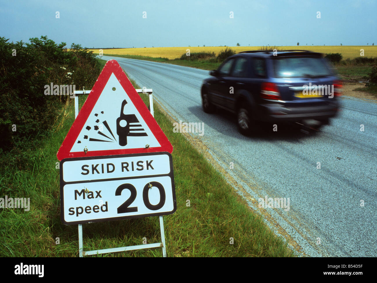 Quatre par quatre passant véhicule panneau d'avertissement de route glissante sur la route nouvellement refait surface près de Leeds Yorkshire UK Banque D'Images