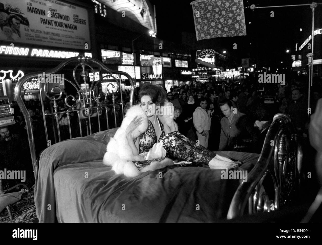 L'actrice Julie Newmar allongé sur un lit en cuivre dans le New York Times Square pour une scène dans le film 'McCloud'. Novembre 1969 Z11482 Banque D'Images