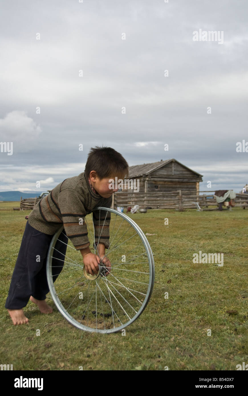Enfant jouant avec une roue le nord de la Mongolie Banque D'Images