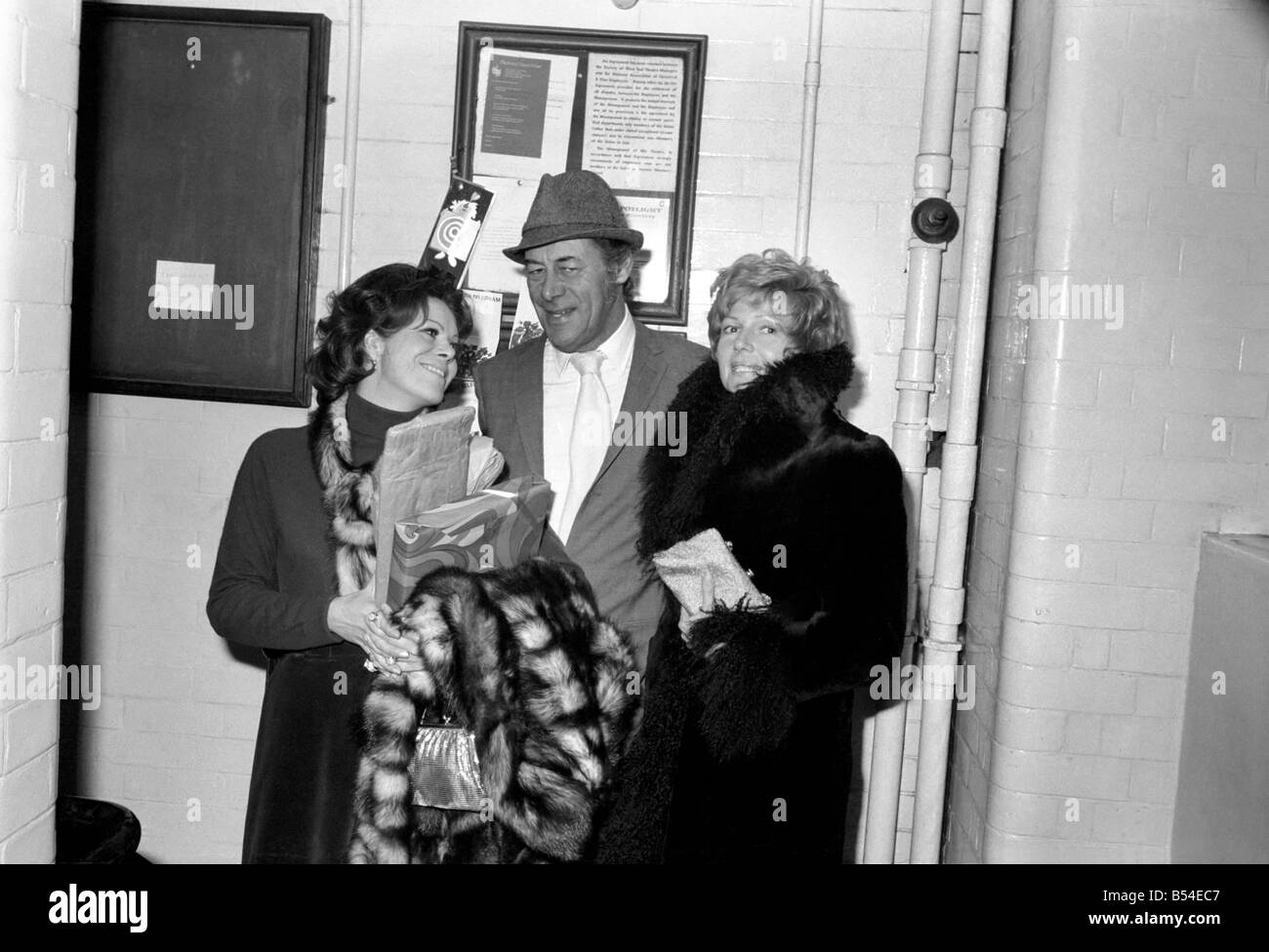 Rex Harrison acteurs de divertissement avec son épouse Rachael Roberts (à gauche) et Rita Hayworth quitte le Lyric Theatre, Shaftesbury Avenue à Londres, après la première nuit de la nouvelle étape comédie de George Hulme - 'Le Lionel Touch' dans lequel Rex Harrison joue le rôle principal de Fairleigh Lionel. Sa femme et Rita Hayworth étaient dans l'auditoire. Novembre 1969 Z10695 Banque D'Images