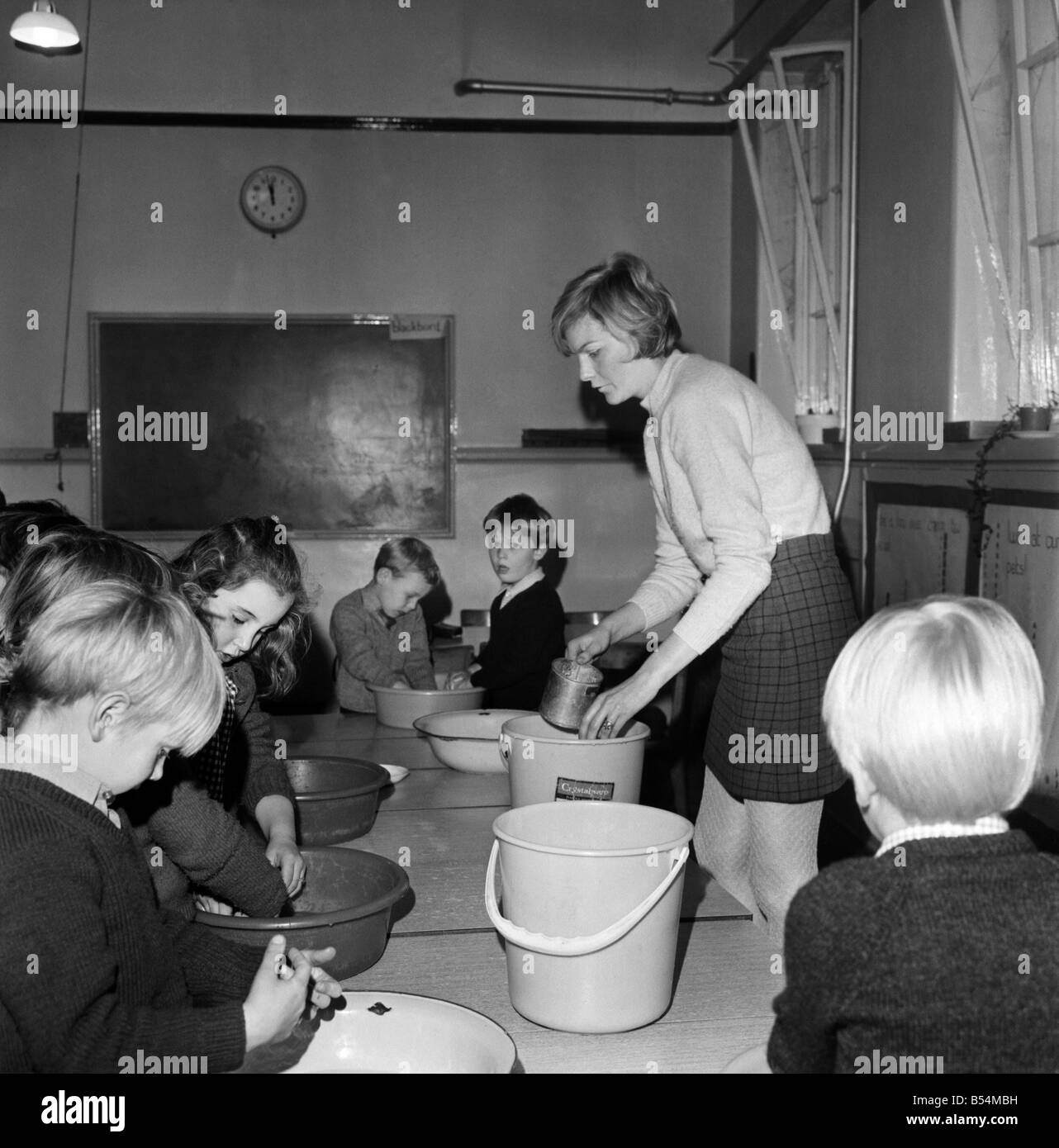 Mme Diana Yeomans, professeur à l'école petit village dans le Yorkshire, Strensall, obtient l'eau chaude de seaux pour les enfants à se laver les mains, prêt pour le déjeuner. ;Novembre 1969 ;Z11532 Banque D'Images