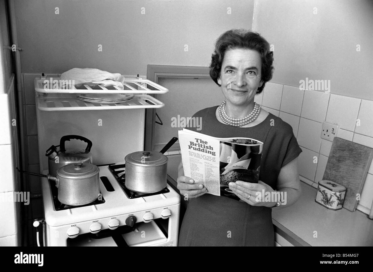Ménage - les tâches domestiques de la cuisson. Une femme à l'aide de son gaz sur dans la cuisine de sa maison. Décembre 1969 Z11588-002 Banque D'Images