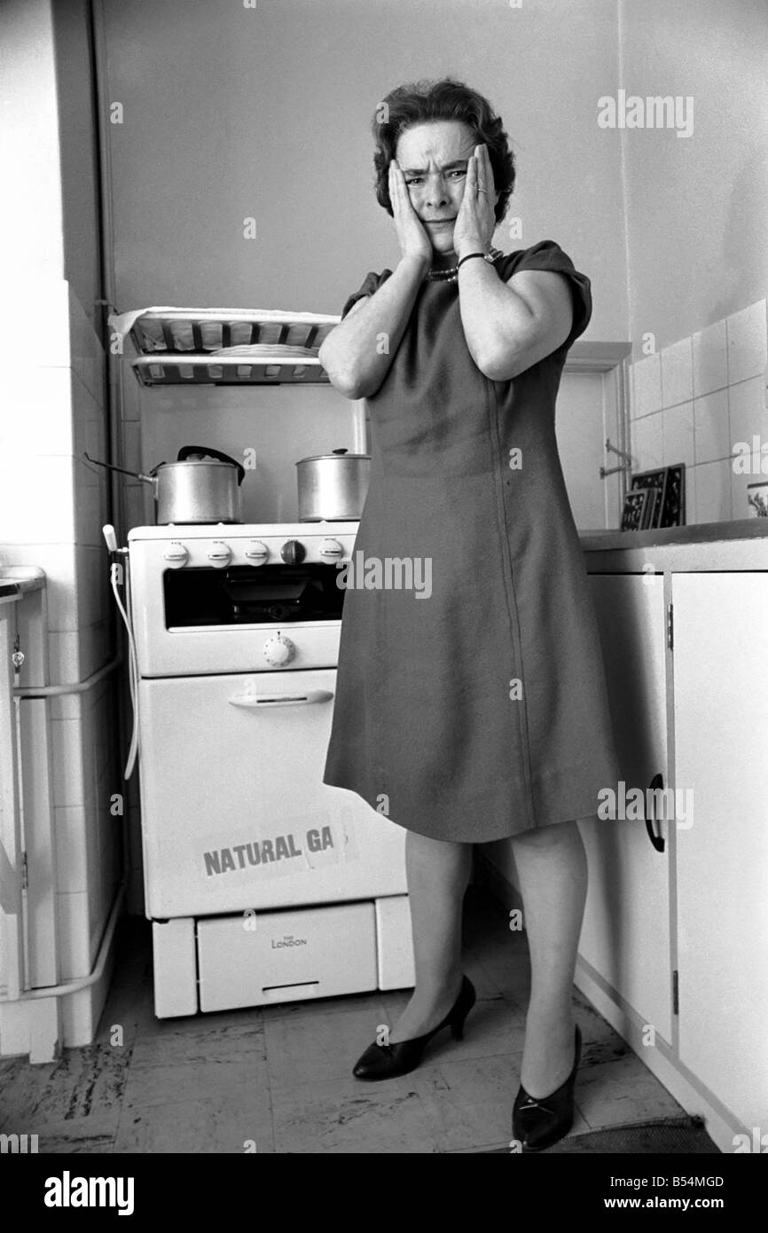 Ménage - les tâches domestiques de la cuisson. Une femme à l'aide de son gaz sur dans la cuisine de sa maison. Décembre 1969 Z11588-003 Banque D'Images