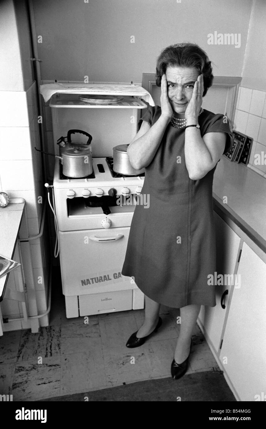 Ménage - les tâches domestiques de la cuisson. Une femme à l'aide de son gaz sur dans la cuisine de sa maison. Décembre 1969 Z11588-004 Banque D'Images