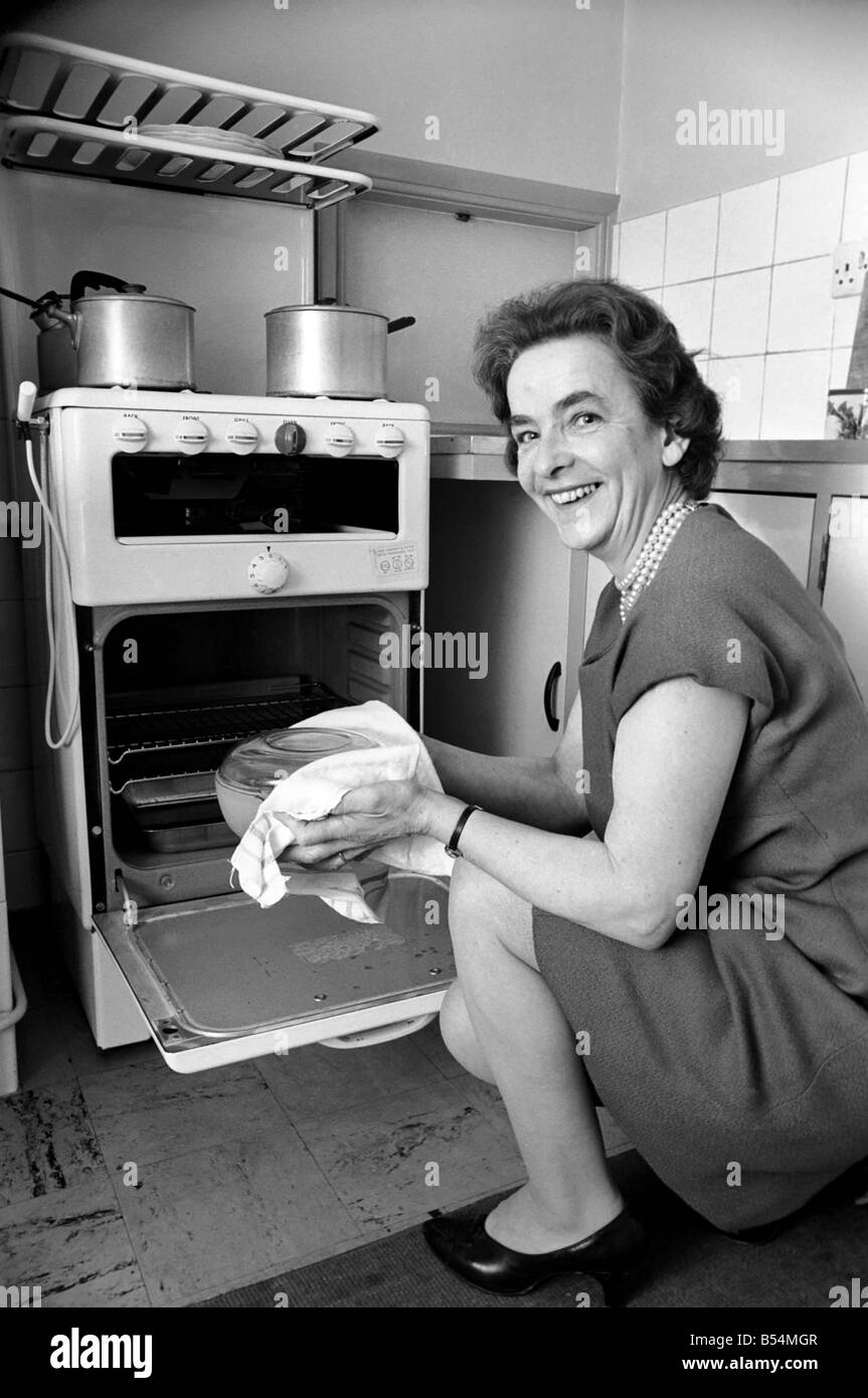 Ménage - les tâches domestiques de la cuisson. Une femme à l'aide de son gaz sur dans la cuisine de sa maison. Décembre 1969 Z11588 Banque D'Images