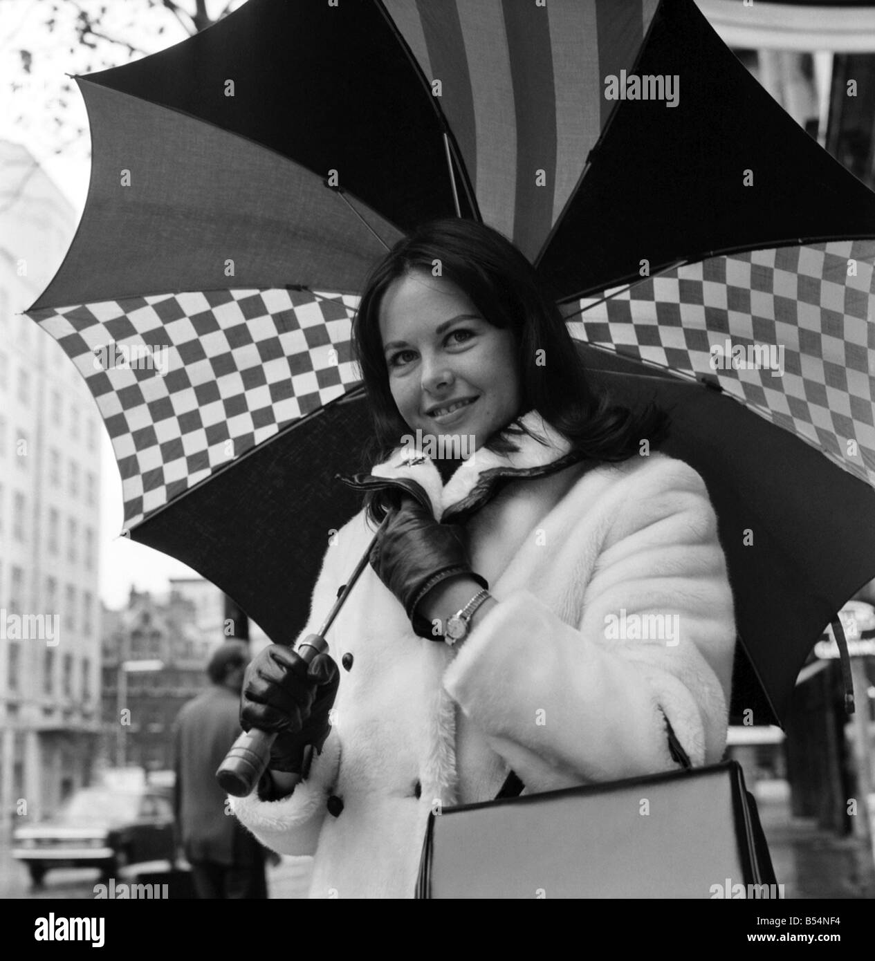 S'avertir et sec pour l'humide froid météo Londres, Miss Canada, 21 ans Jacquie Perrin, un étudiant de Toronto, Canada. On voit ici l'extérieur de l'hôtel Waldorf où elle séjourne. Novembre 1969 Z11077-001 Banque D'Images