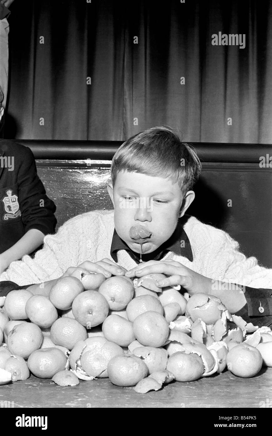 Records : Humour : Enfants : Rencontrez Guenter Kuhn le champion du monde de 14 ans, qui aujourd'hui mangeur d'orange (Sam) s'est assuré de son titre lorsqu'il dévorait 19 oranges à 2 minutes ensuite manger 34 (répétez 34) plus juste pour montrer qu'il était un vrai champion. Novembre 1969 Z11474-003 Banque D'Images