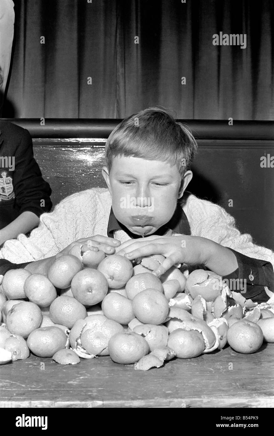 Records : Humour : Enfants : Rencontrez Guenter Kuhn le champion du monde de 14 ans, qui aujourd'hui mangeur d'orange (Sam) s'est assuré de son titre lorsqu'il dévorait 19 oranges à 2 minutes ensuite manger 34 (répétez 34) plus juste pour montrer qu'il était un vrai champion. Novembre 1969 Z11474-004 Banque D'Images