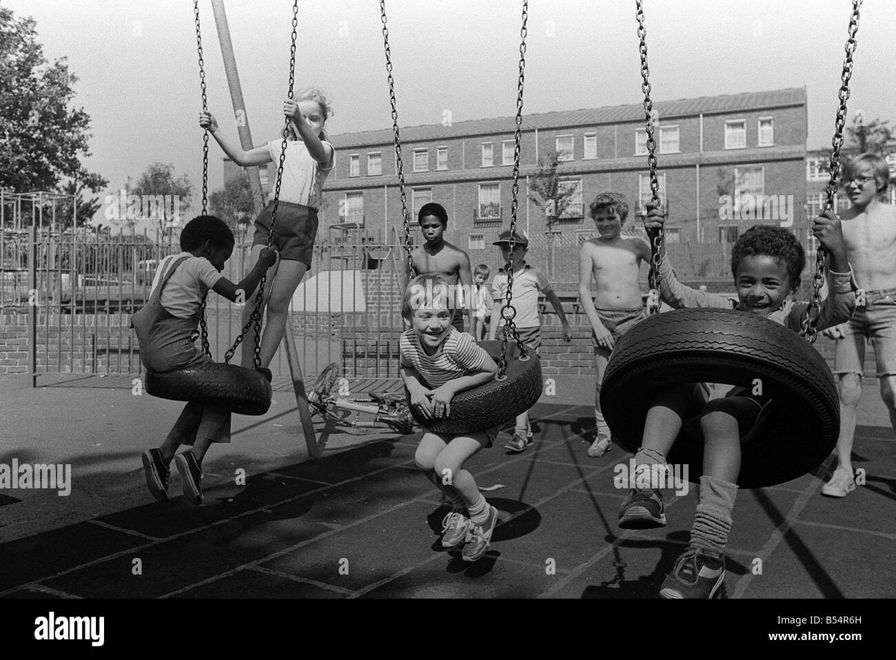 Notting Hill Carnival Août 1981 enfants jouant sur la balançoire dans le terrain de jeux près de l'Portabello Road Banque D'Images