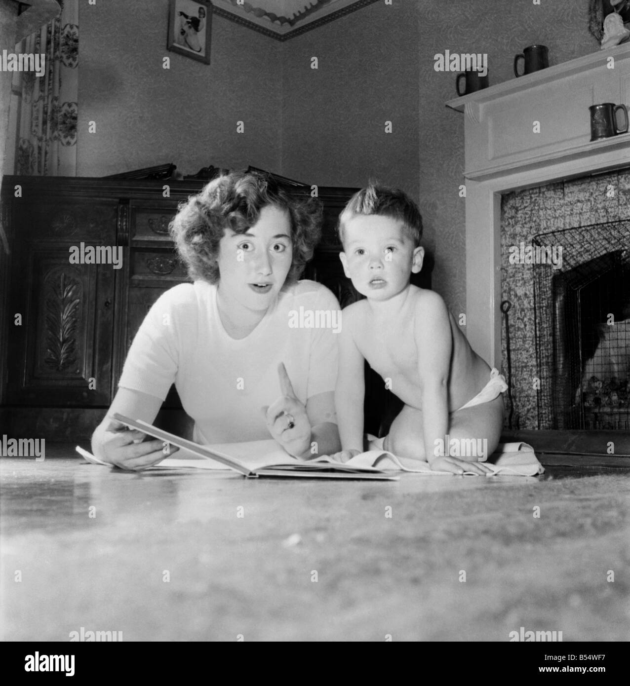 La famille cornichon est une famille solide que ces photo voir maman et papa la formation de poids avec fils Eric. Mère et fils vu lecture Novembre 1953 D6683 Banque D'Images