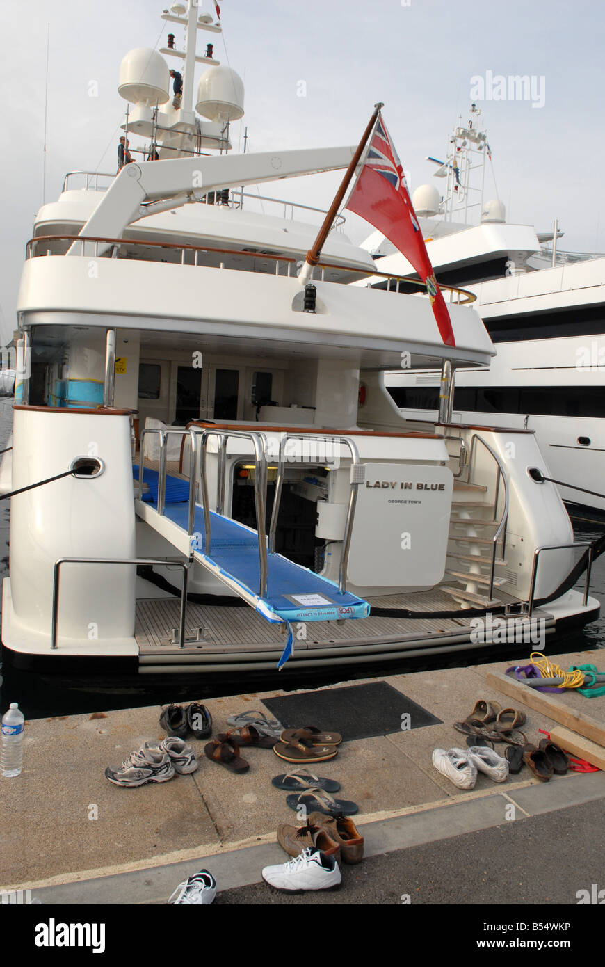 Les congés du personnel leurs chaussures sur le quai tout en travaillant sur un yacht de luxe dans le port à Antibes dans le sud de la France Banque D'Images Les congés du personnel leurs chaussures sur le quai tout en travaillant sur un yacht de luxe dans le port à Antibes dans le sud de la France Banque D'Images