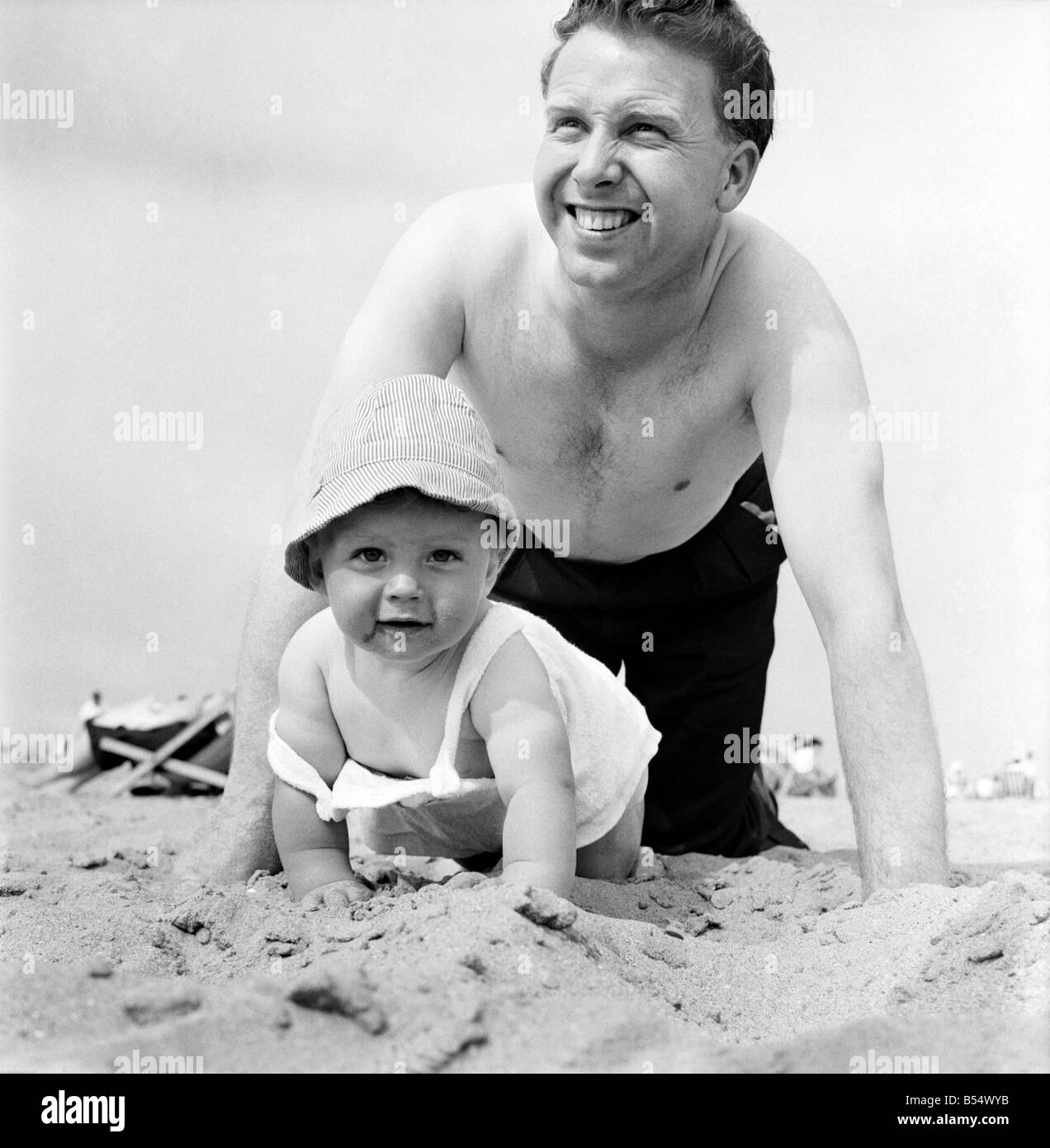 Neuf mois Paul Kemshell de ramper sur le sable à Rhyl avec son papa Monsieur Brian Kemshell de Muro. Juin 1960 M4315-005 Banque D'Images