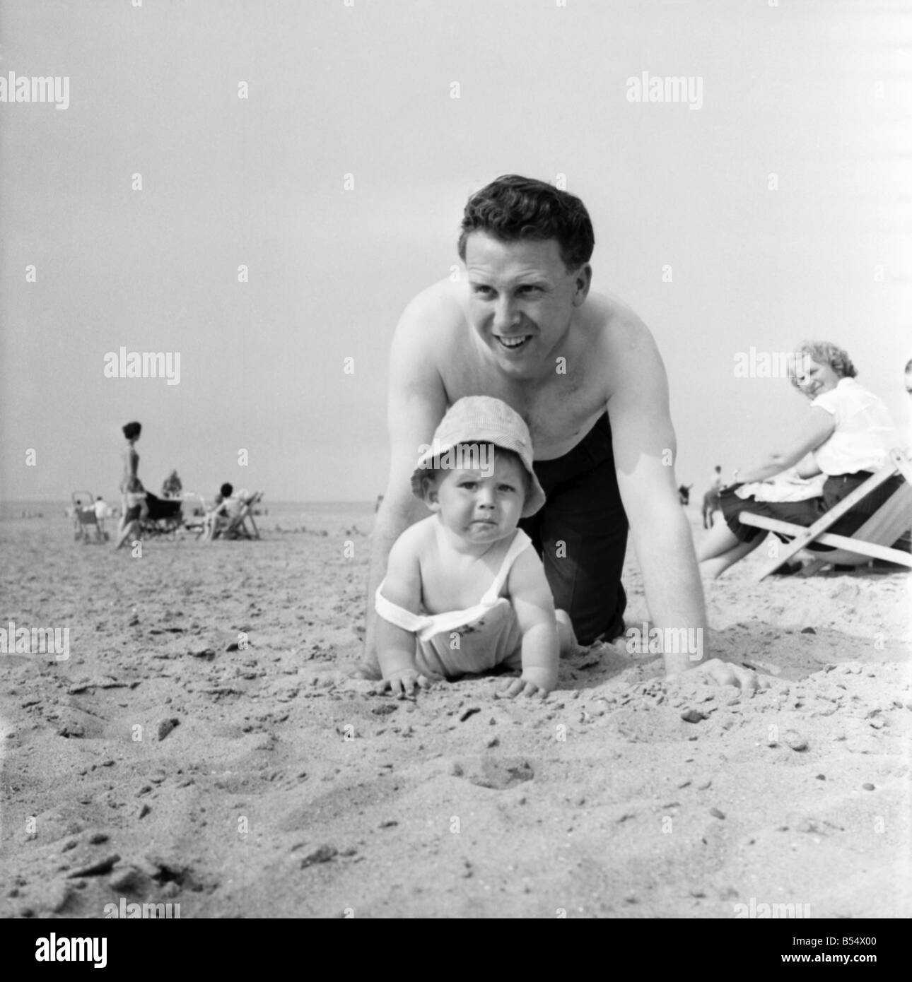 Neuf mois Paul Kemshell de ramper sur le sable à Rhyl avec son papa Monsieur Brian Kemshell de Muro. Juin 1960 M4315-014 Banque D'Images