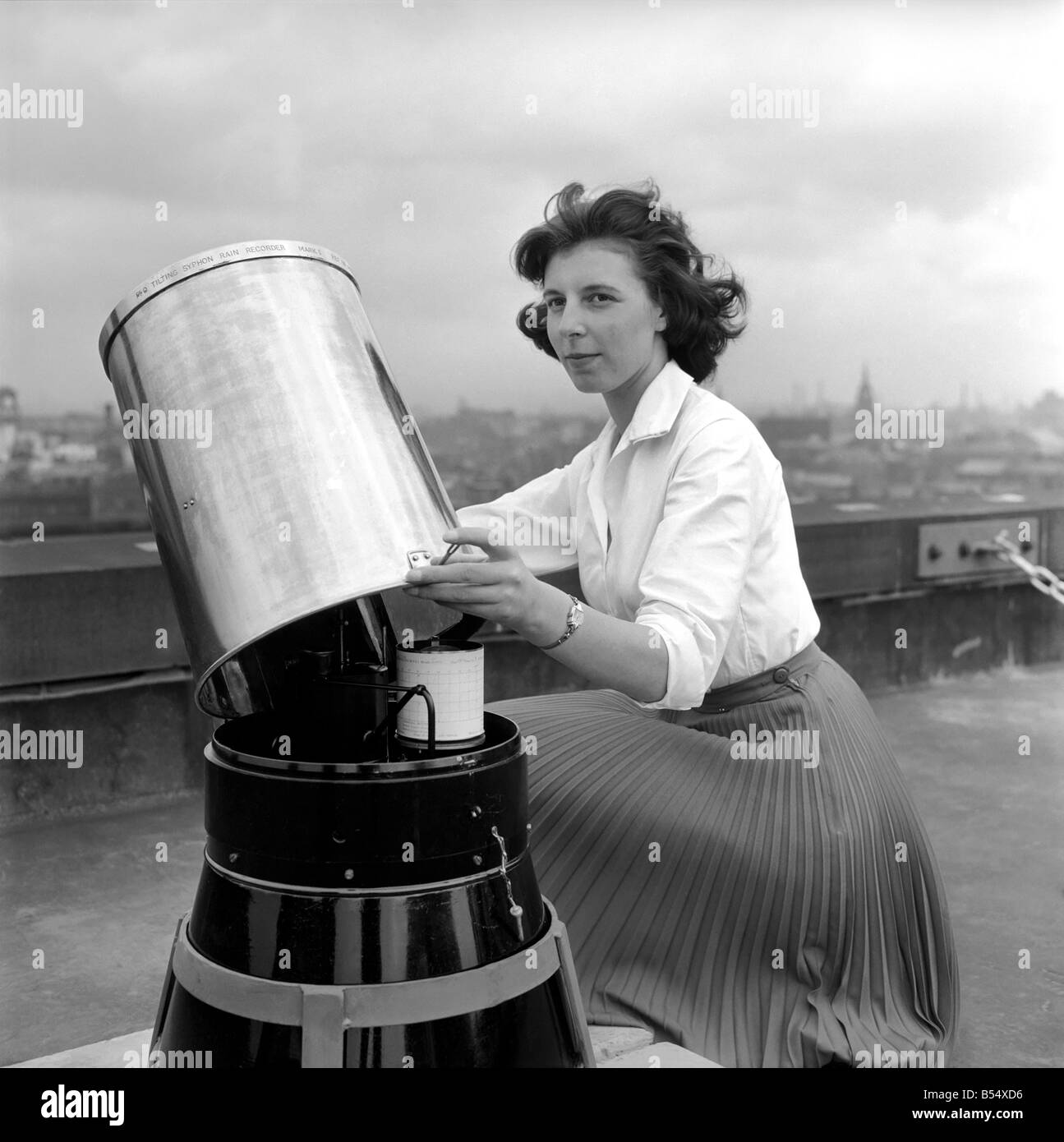 22 ans de Dinah Sutcliffe Todmorden, un scientifique à la nouveau centre météo au Royal Exchange Manchester démontre l'un des nouveaux enregistreurs de pluie-mis en place avec d'autres équipements sur le toit de l'immeuble. Juin 1960 ;M4499 Banque D'Images