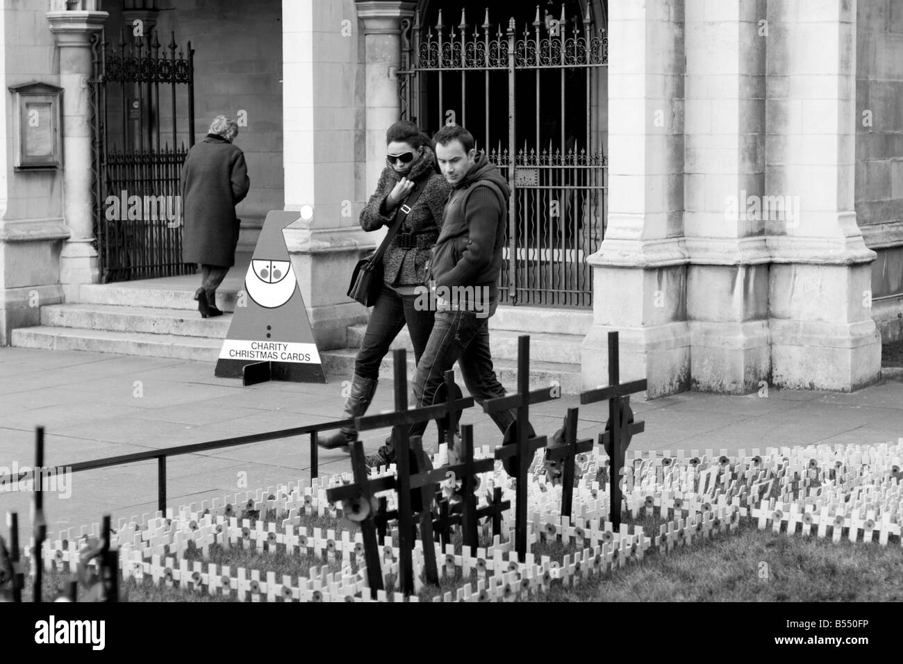 Couple walking passé un jardin commémoratif avec mini traverse et coquelicots Banque D'Images