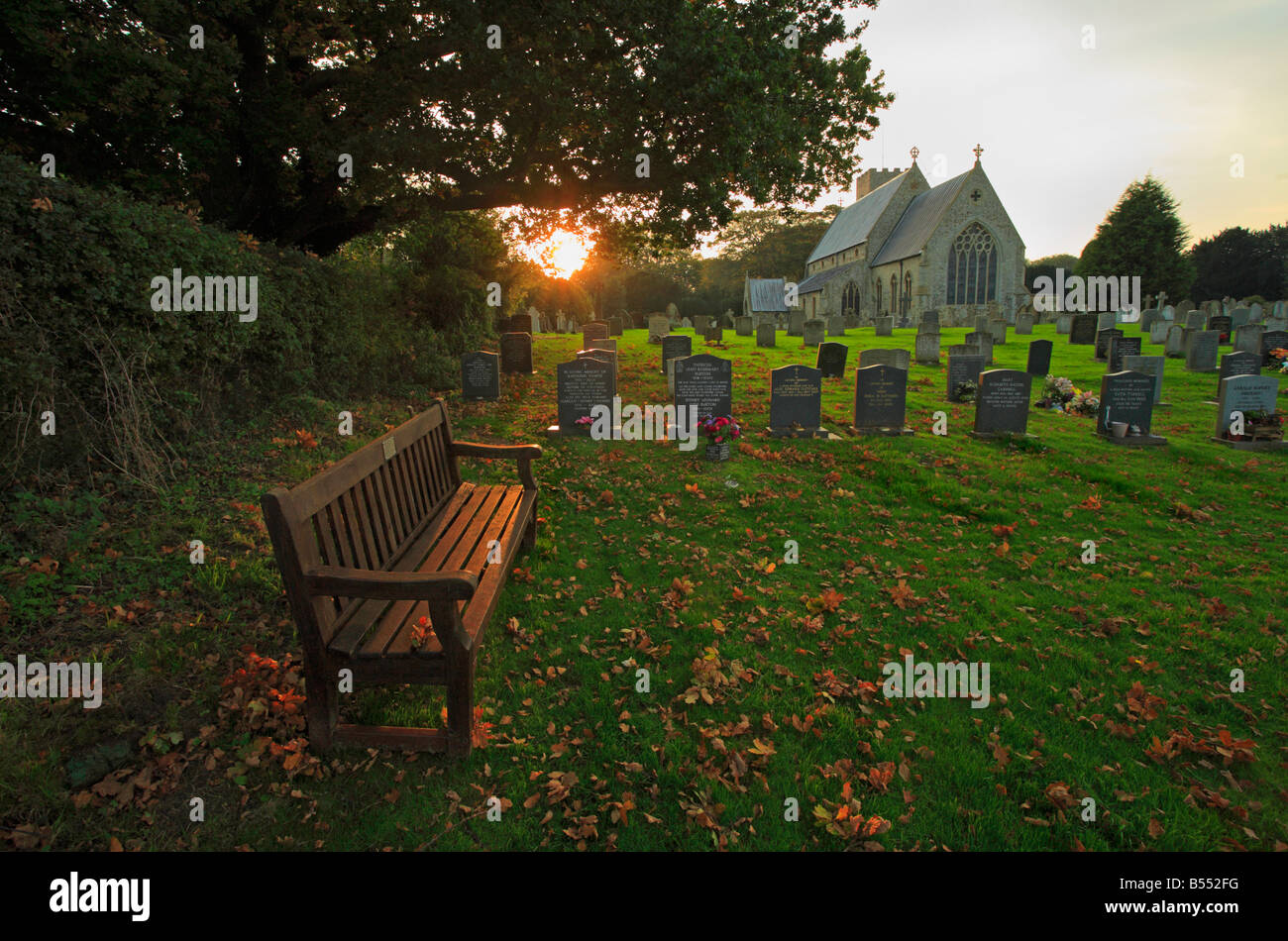 Un banc dans le cimetière à St Mary's Church, Old Hunstanton, Norfolk. Banque D'Images