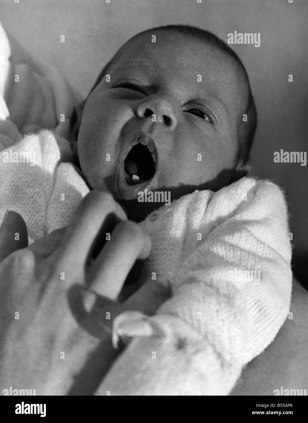 Tanya, le bébé qui est venu avec une première dent. C'est un grand moment dans toute la vie du bébé, de la coupe de la première dent. Pour ces étapes par les parents ne les progrès de leur progéniture graphique. Vous pouvez comprendre, alors , pourquoi Roger Fox et son épouse Elizabeth sentir spécialement fière de leur premier-né, Tanya, photographié ici. lorsqu'elle est née il y a trois semaines - pesant 71b.20z. - Sa première dent a déjà été à travers. Un vrai whopper, droit dans l'avant.mettant son mois d'avance sur ses contemporains. Foger, 24, un opérateur de fibre de verre, dit Tanya étonné les infirmières à la maison de maternité à Woking, Surrey Banque D'Images