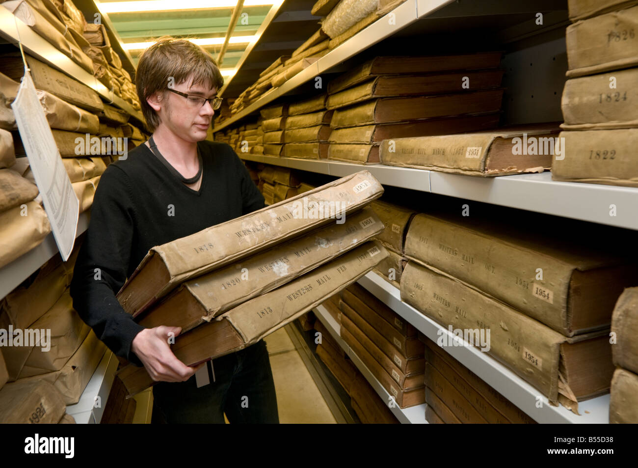 Un homme dans la Bibliothèque nationale du Pays de Galles de la récupération de vieux exemplaires du journal du Western Mail archives en préparation pour la numérisation, UK Banque D'Images