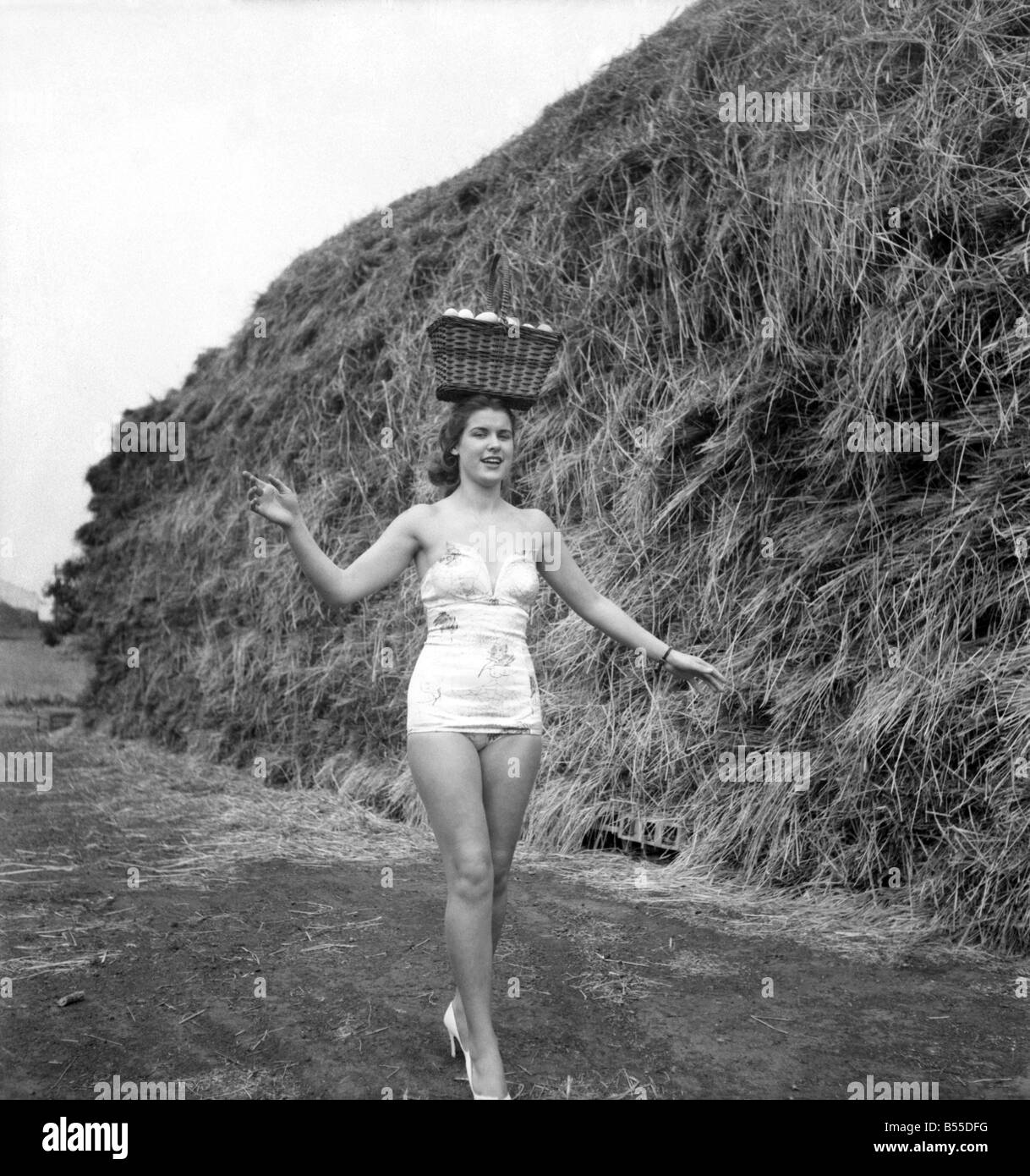 Les femmes l'humour : quand d'autres modèles utiliser les livres pour pratiquer leur équilibre lors de la marche, Syd Owen utilise un panier plein d'œufs. vrais œufs à 6/3 d'une douzaine. Septembre 1953 D5651-003 Banque D'Images