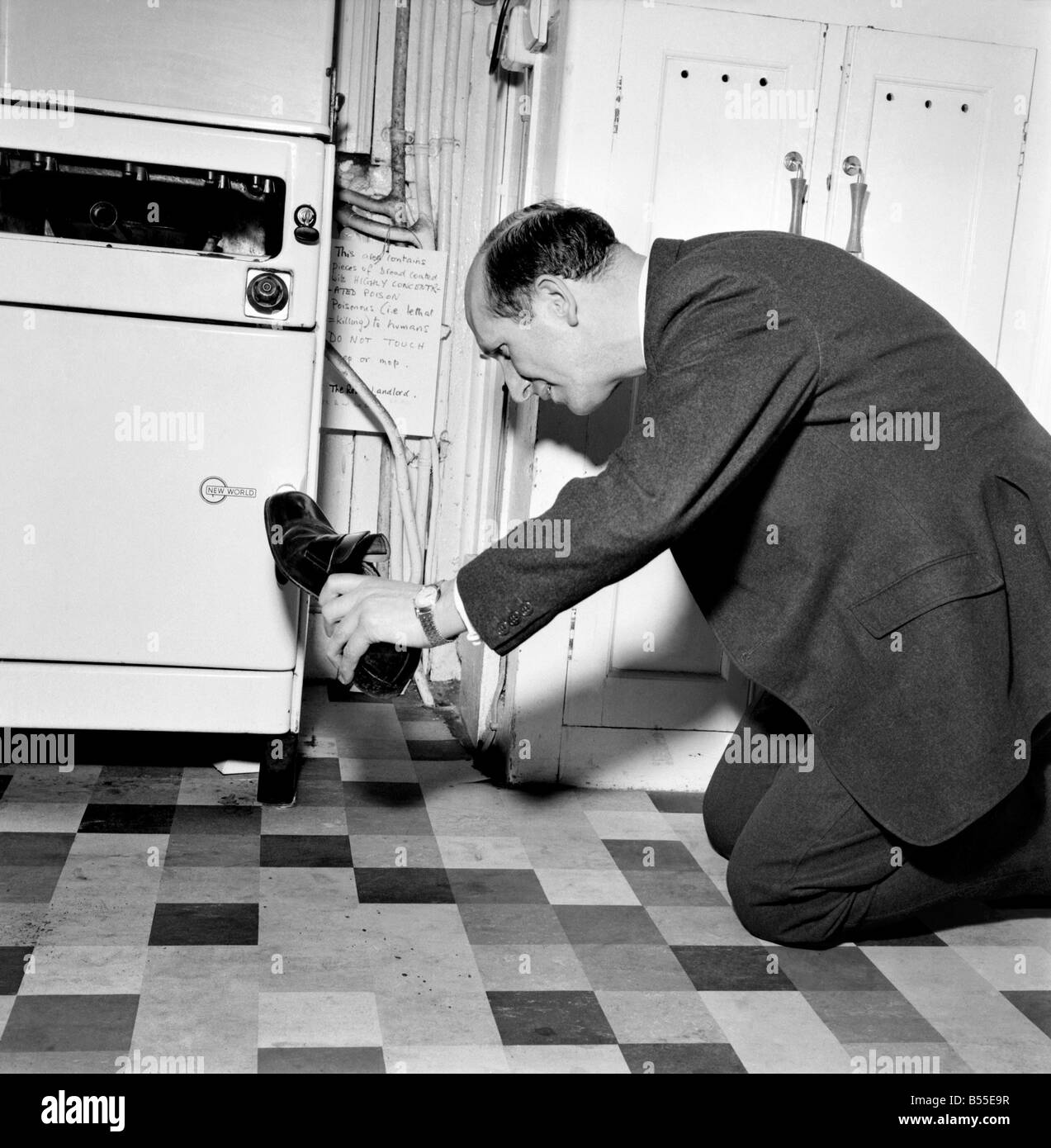 L'humour : Le Rev Brian Bason chaussure dans la main se prépare à faire un kill dans sa bataille avec la souris. Décembre 1969 Z12085 Banque D'Images