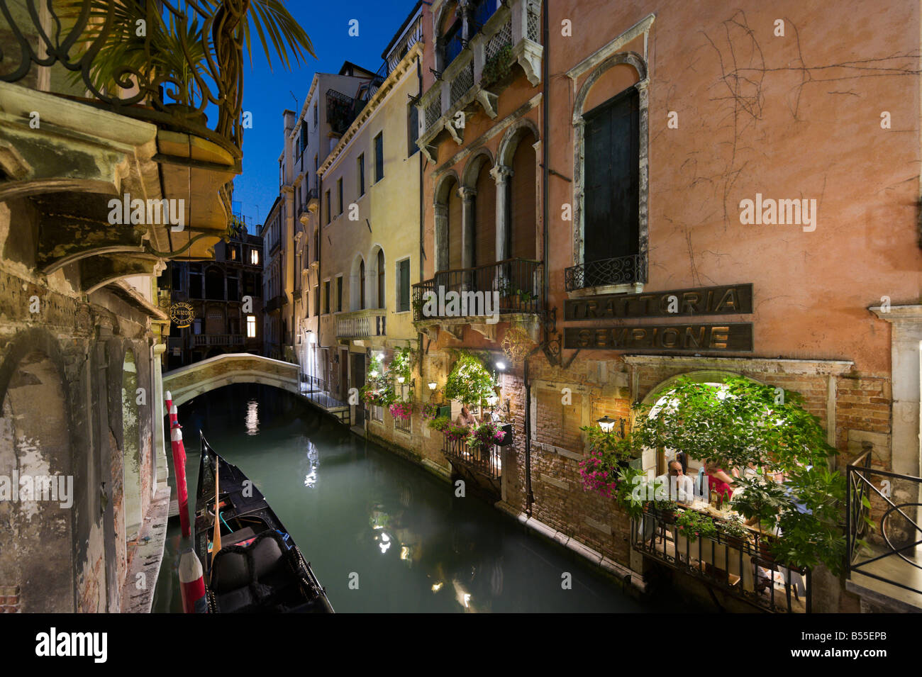 Dîner dans un restaurant au bord du canal de nuit, San Marco, Venise, Vénétie, Italie Banque D'Images