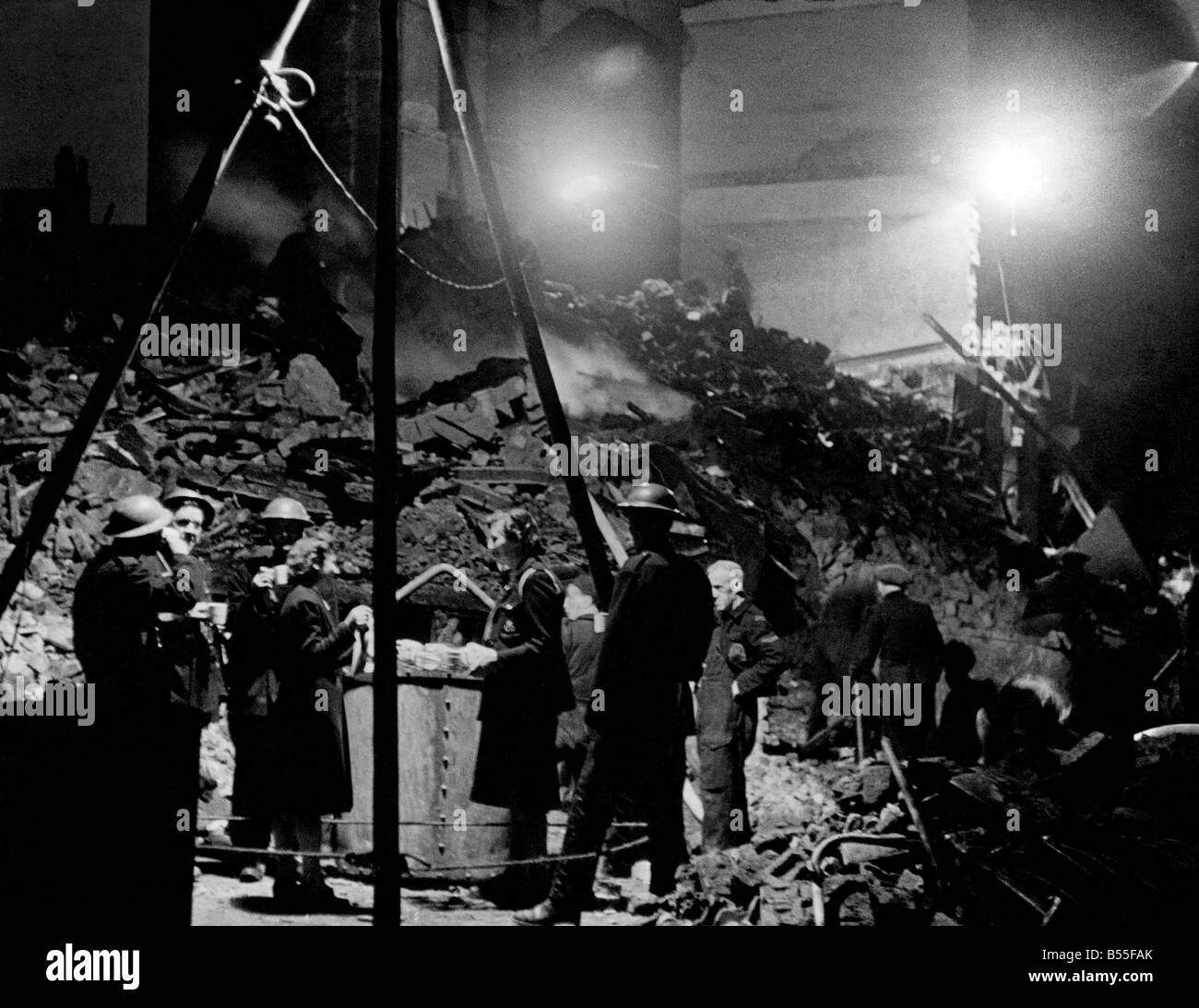 Service national des sapeurs pompiers de la défense civile et obtenir une pause pour le thé qui a été amenée sur un plateau rond par les femmes libres de travailleurs. Les gens étaient coincés sous les débris d'appartements dans le sud de l'Angleterre et ont été recherchées et creusés par les lumières des torches dans la nuit. ;Août 1944;P009374 Banque D'Images