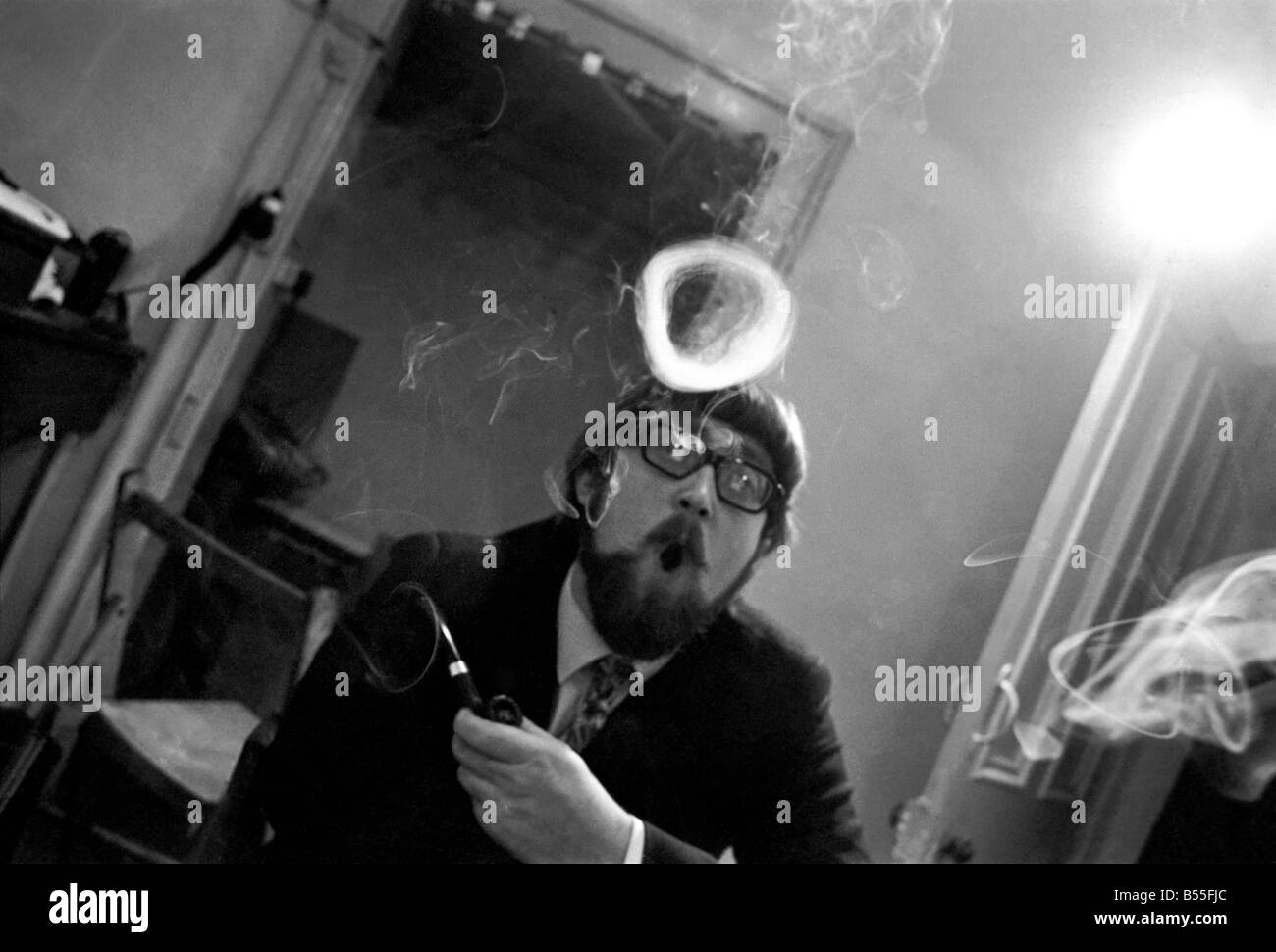 Un homme fume une cigarette soufflant des ronds de fumée. Novembre 1969 &# 13 ;&# 10;Z12004-005 Banque D'Images