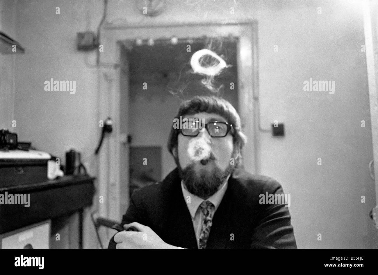 Un homme fume une cigarette soufflant des ronds de fumée. Novembre 1969 &# 13 ;&# 10;Z12004-007 Banque D'Images