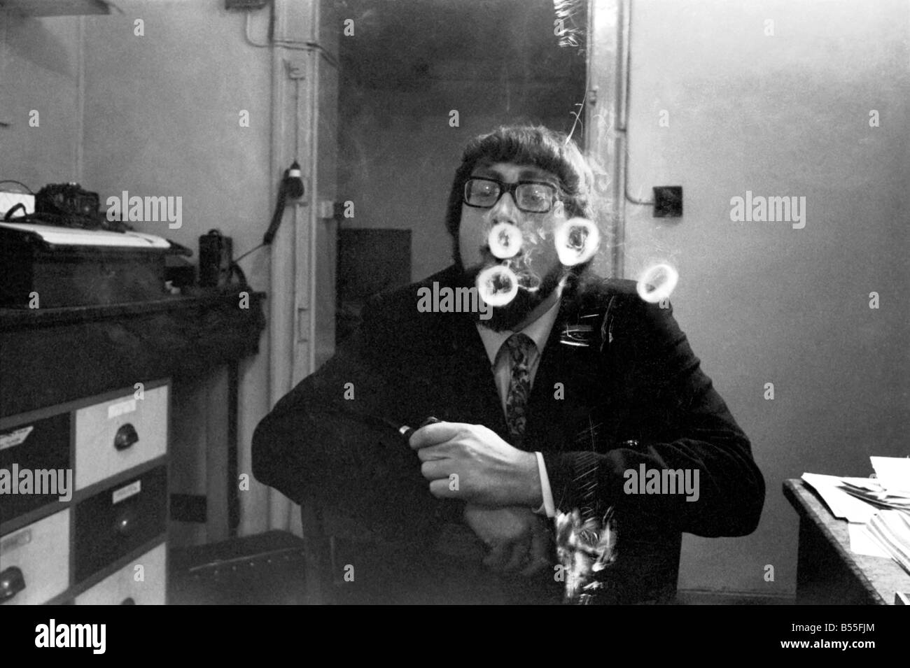 Un homme fume une cigarette soufflant des ronds de fumée. Novembre 1969 &# 13 ;&# 10;Z12004-009 Banque D'Images