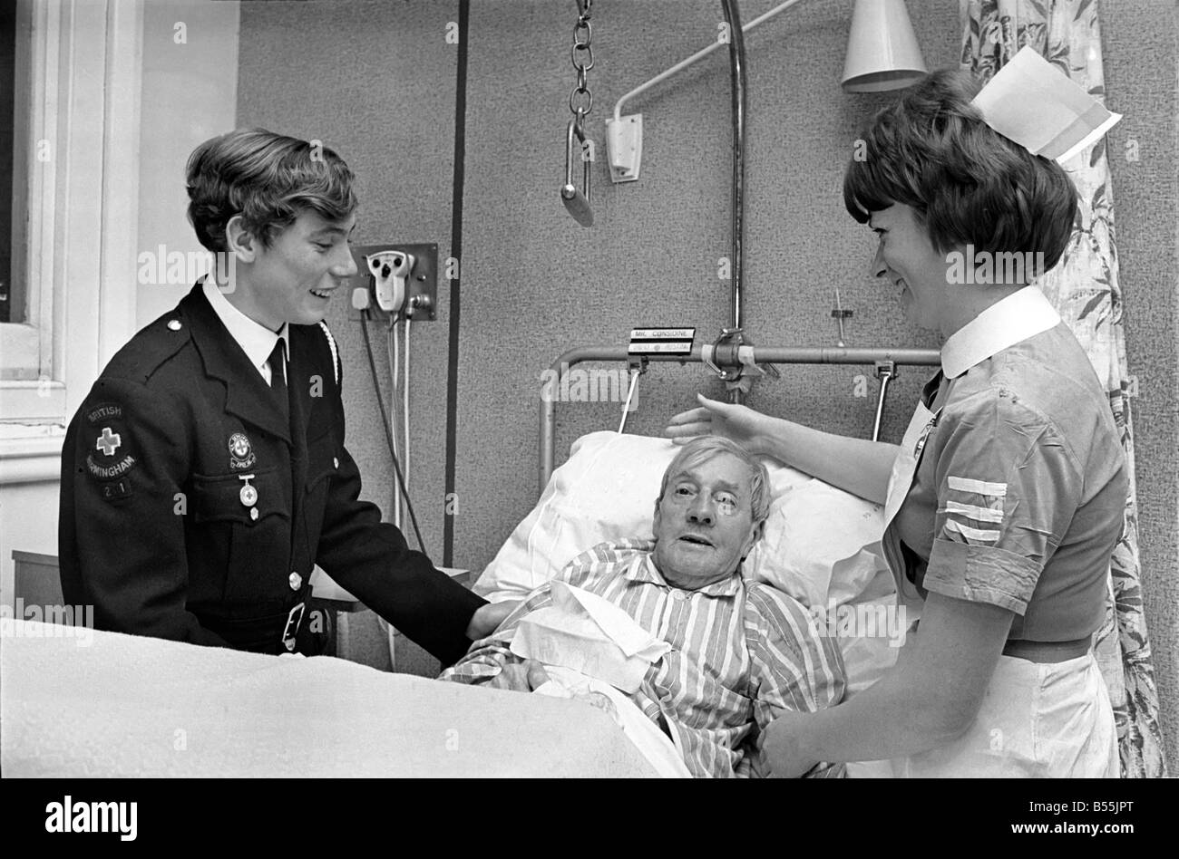 Le travail bénévole dans les hôpitaux. 15 ans Robert Newport aider l'infirmière en charge du quartier 3 à l'hôpital de Birmingham est infirmière  ; Margaret Flaherty d'assister aux besoins de M. patient David Austin. ;Décembre 1969 ;Z12495-004 Banque D'Images