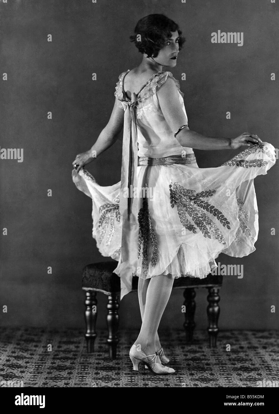 Les vêtements. La robe de mousseline blanche debutante avec jupe en forme de pétales brodés de gouttelettes de feuilles vertes. Argent Bijoux Banque D'Images