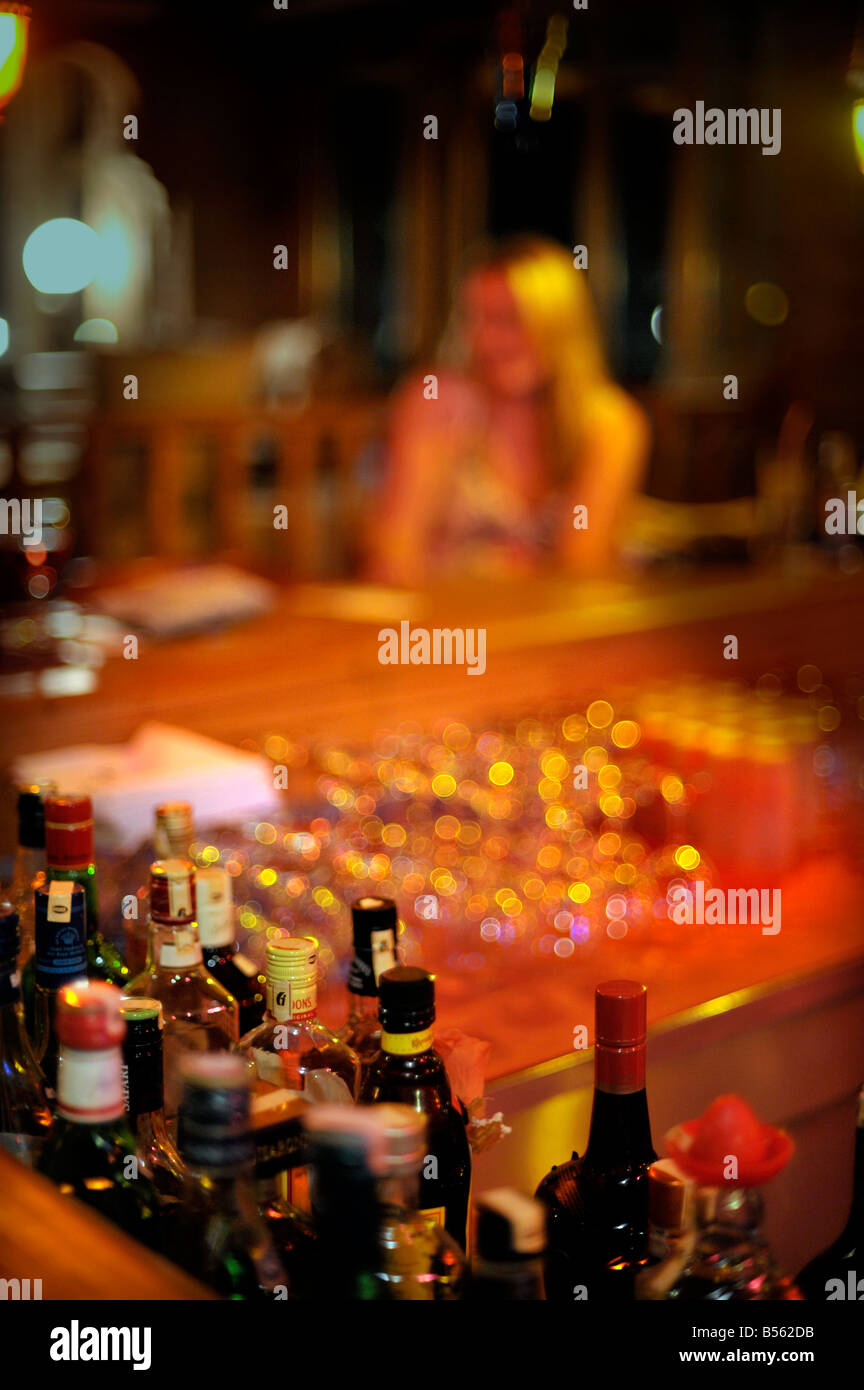 Femelle solitaire avec de longs cheveux blonds assis seul au bar Banque D'Images