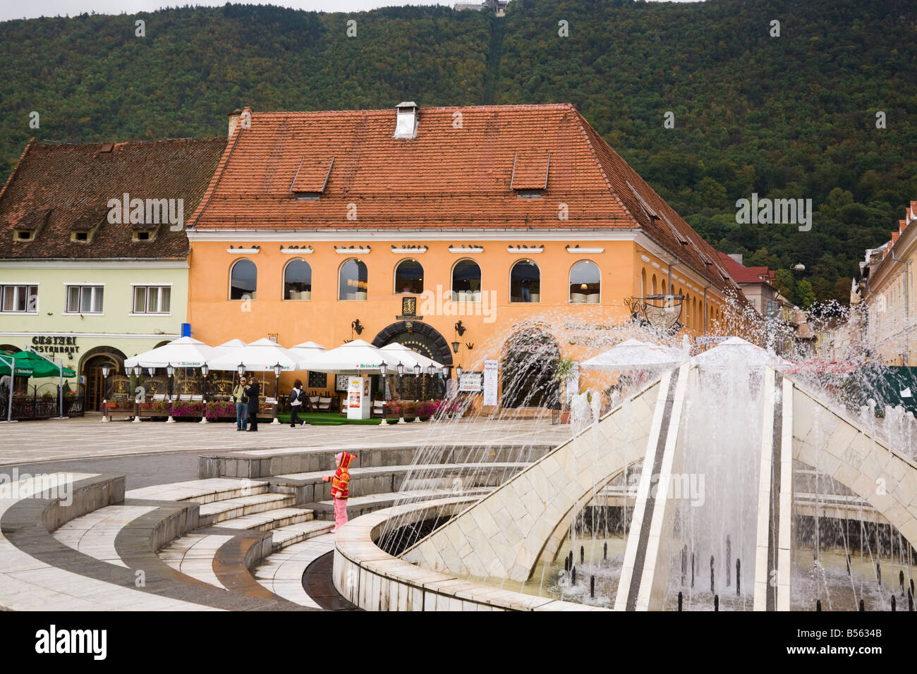 Fontaine en zone piétonne Place du Conseil Piata Sfatului avec terrasses des cafés dans le centre-ville médiéval de Transylvanie de Brasov Roumanie Banque D'Images