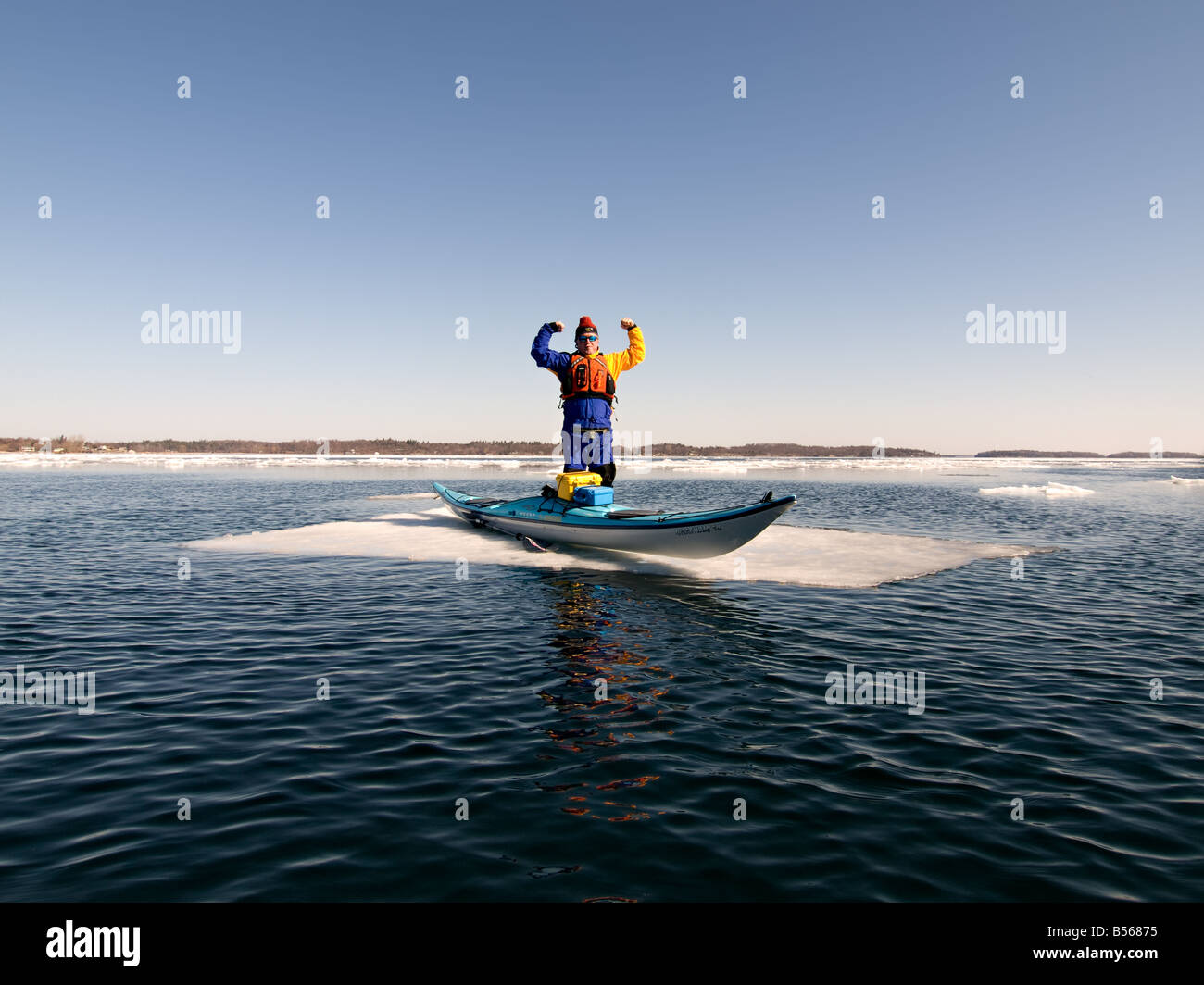 Un homme debout à côté d'un kayak sur une plaque de glace au milieu du fleuve Saint-Laurent. Banque D'Images
