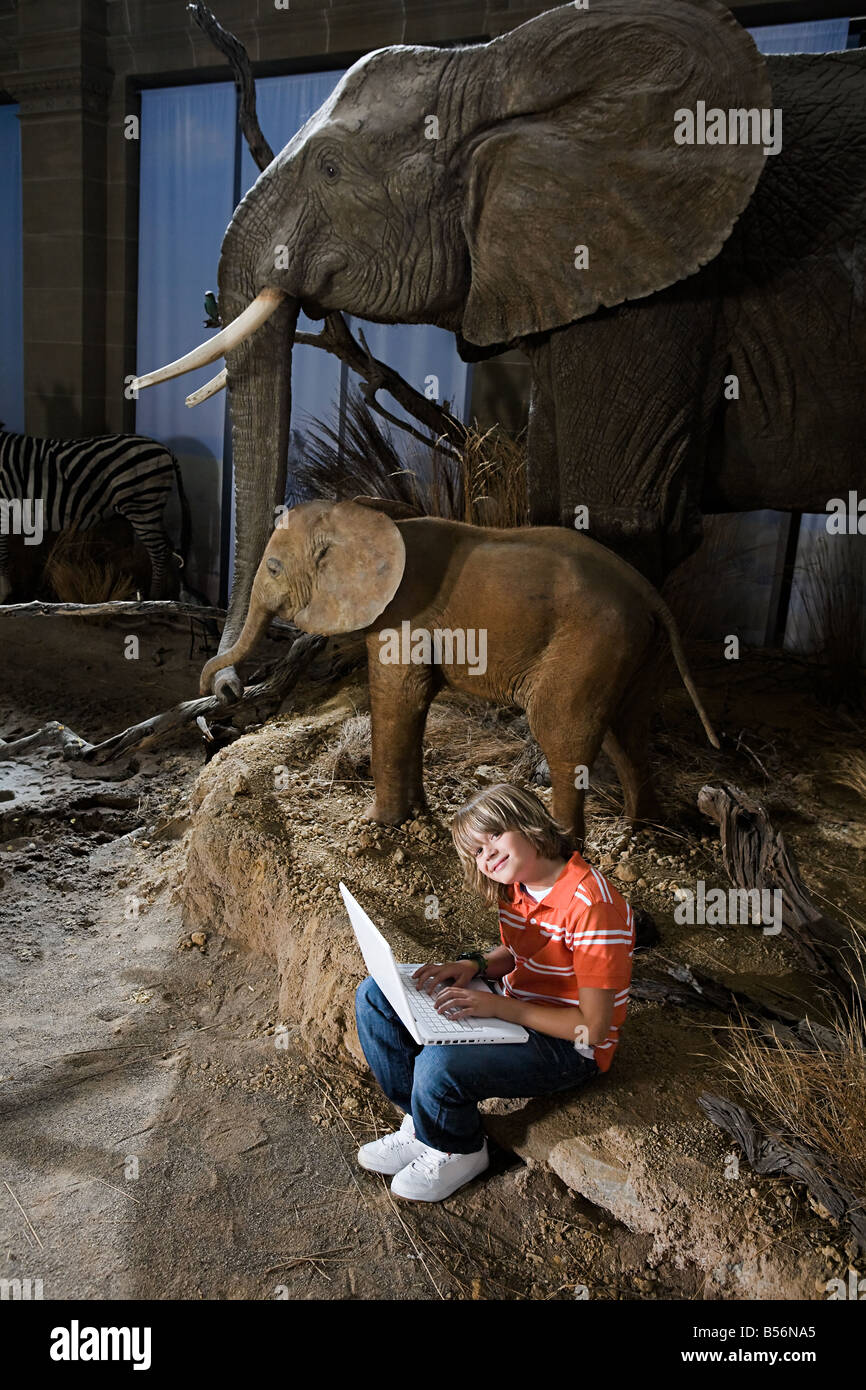Garçon en utilisant un ordinateur portable dans un musée Banque D'Images